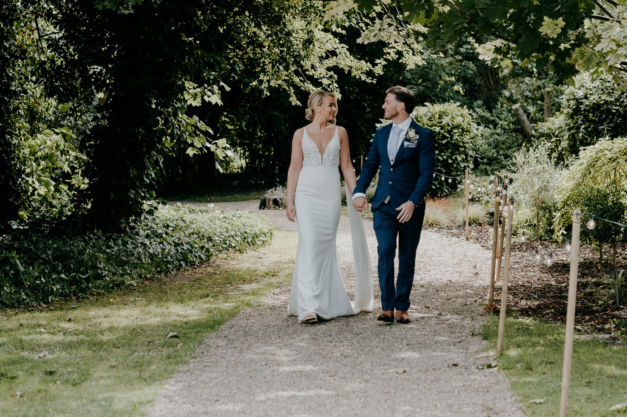Bride and groom holding hands walking together at Dunstan Hall Estate in Derbyshire