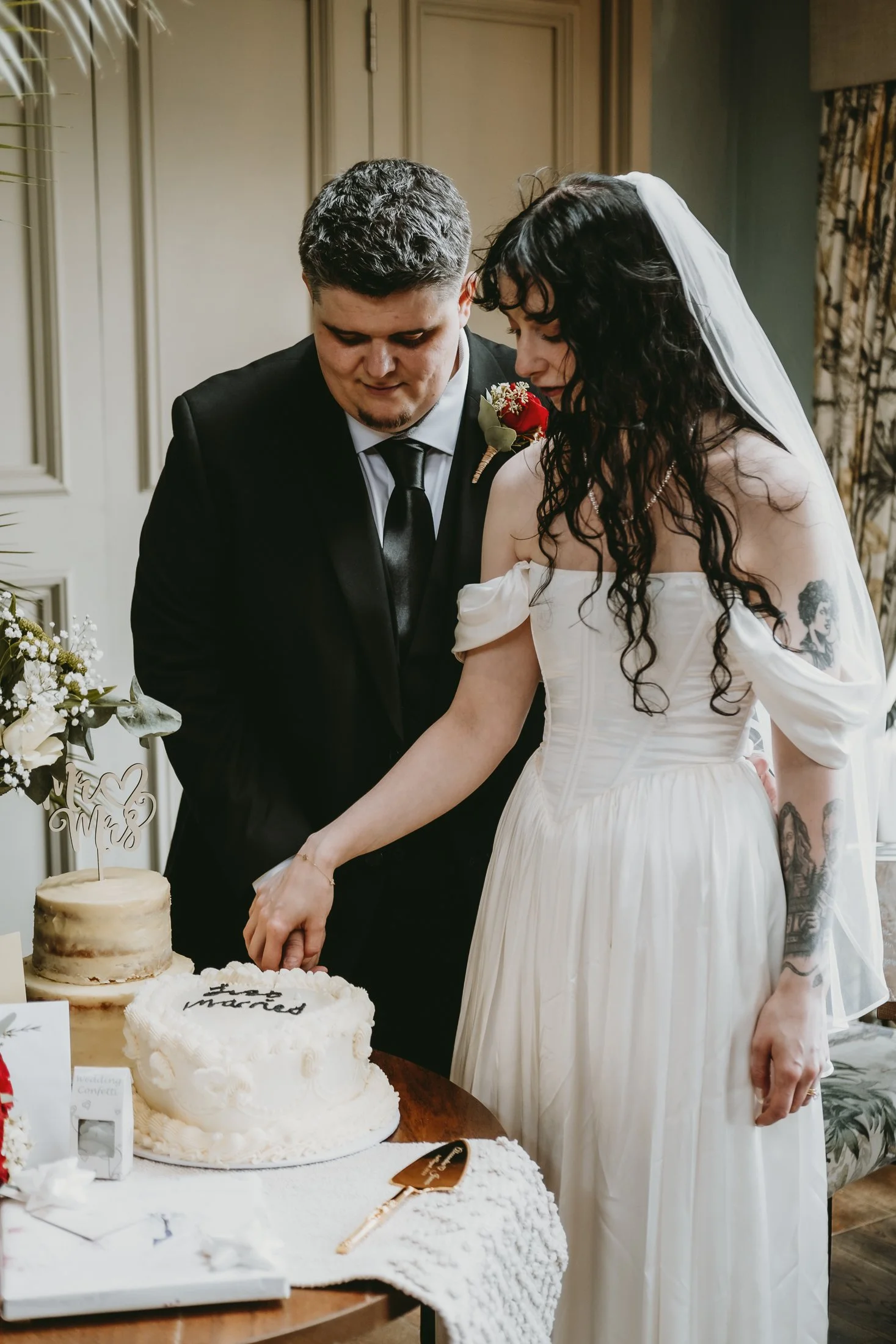 A bride and groom cutting their wedding cake together at their wedding reception.