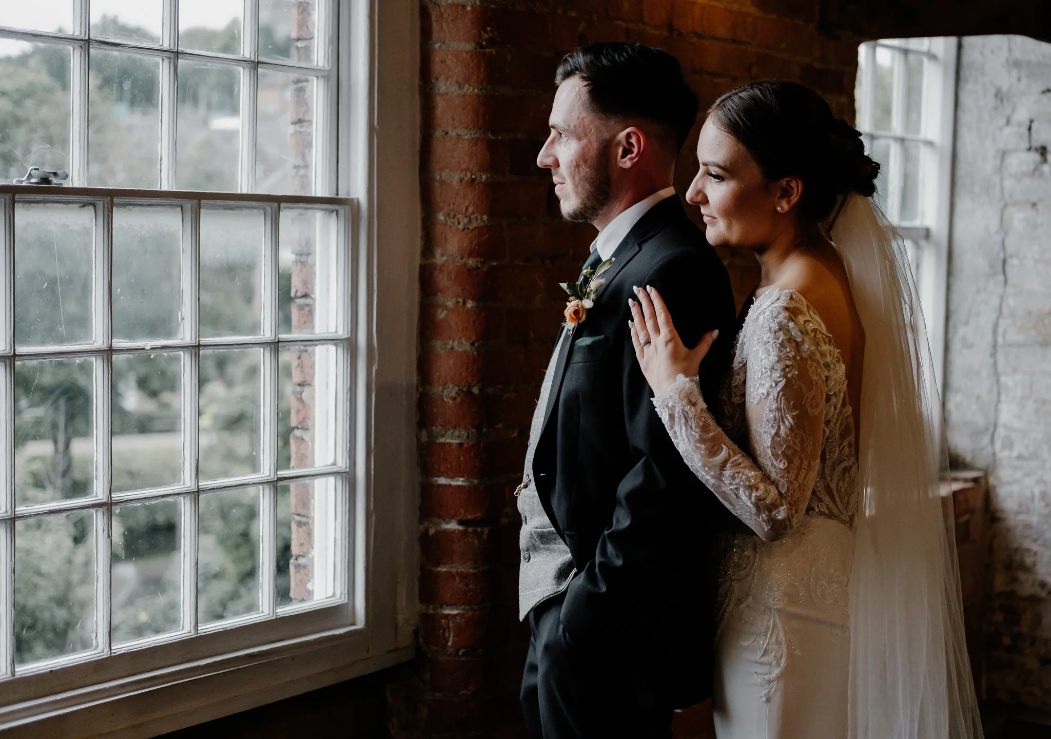 Bride and groom looking out of the window at the West Mill wedding venue in Derby