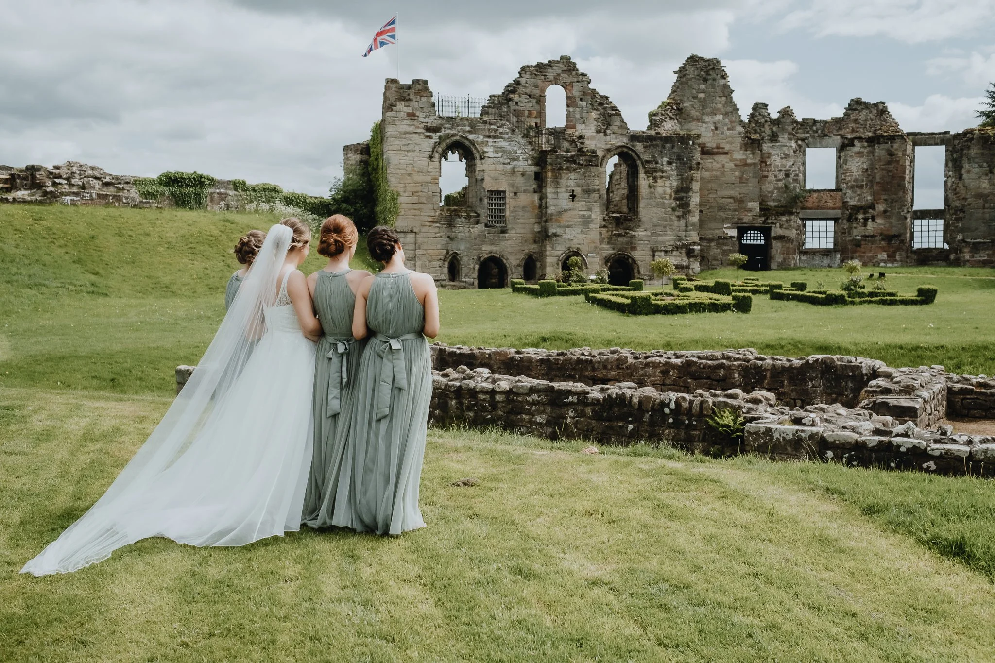 a bride and her bridesmaids looking at the ruins of Tutbury Castle in Staffordshire