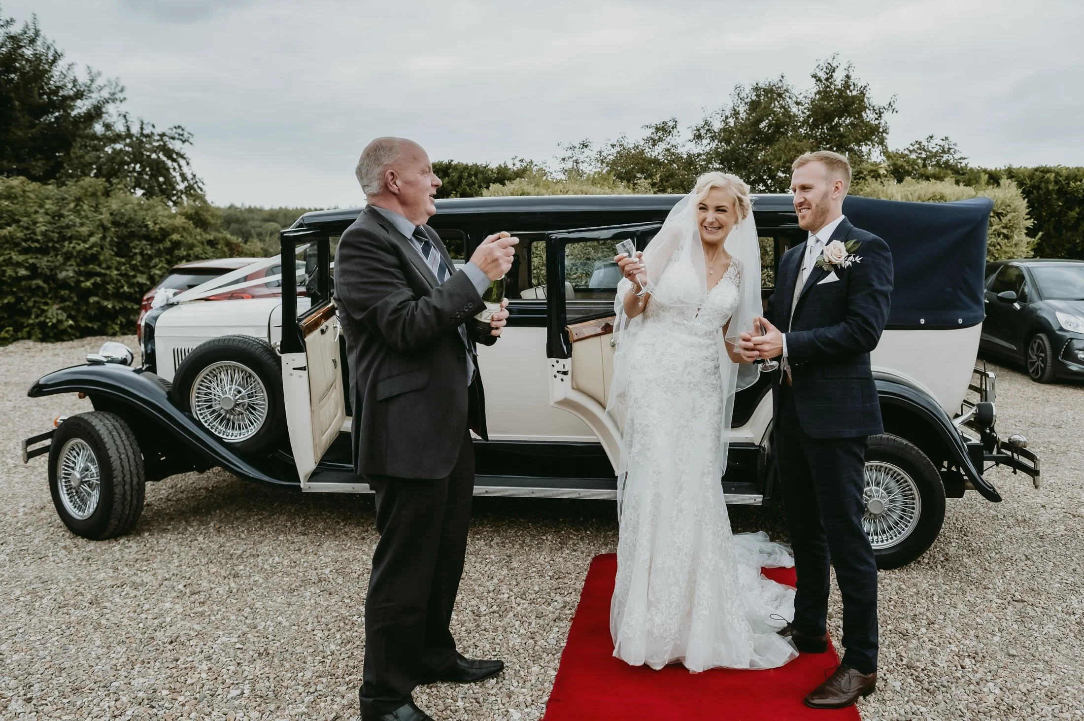Bride and groom having champagne by the wedding car at Horspool Spa in Southwell