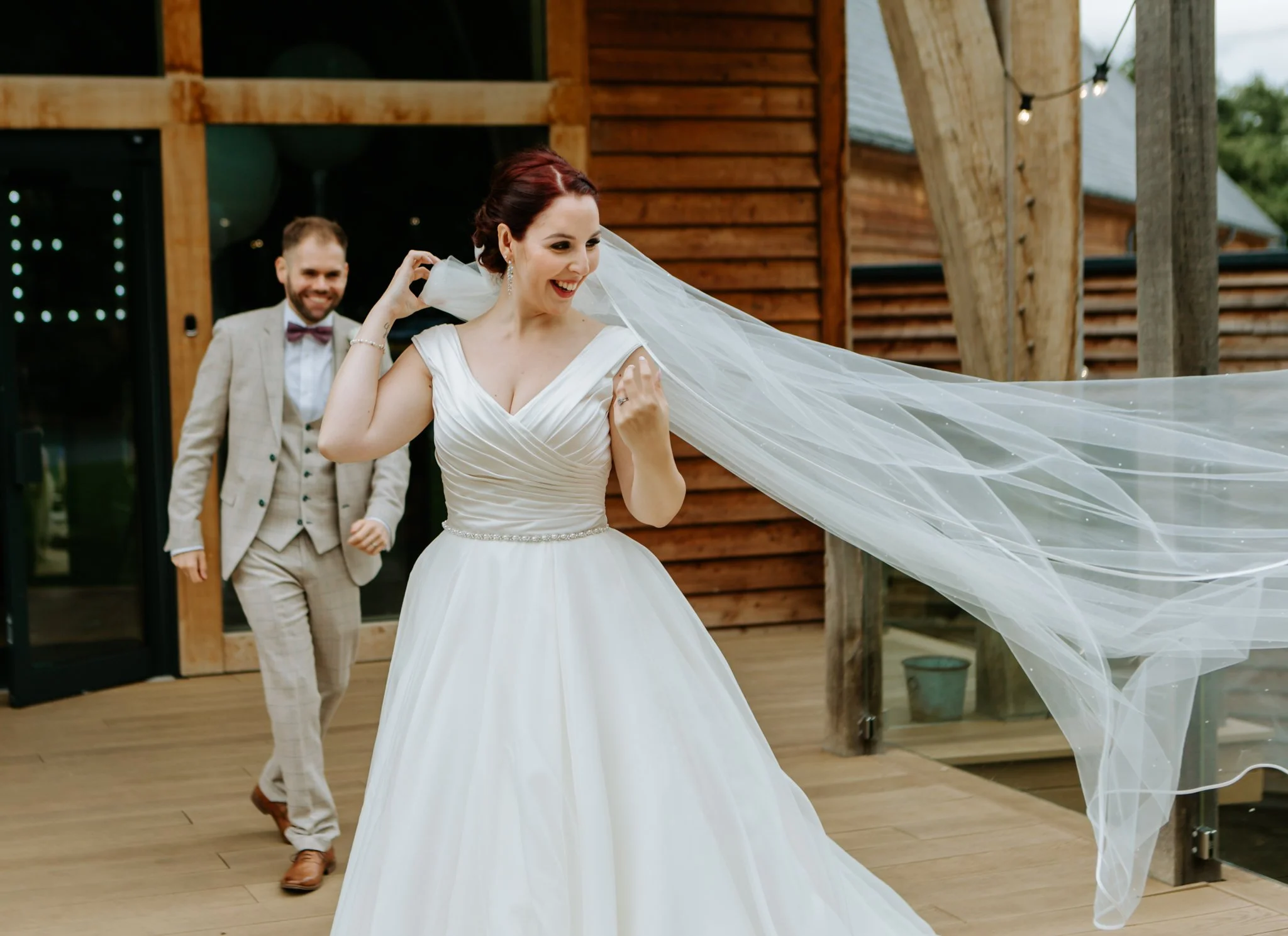 bride standing in the wind with her veil blowing at the Mill Barns