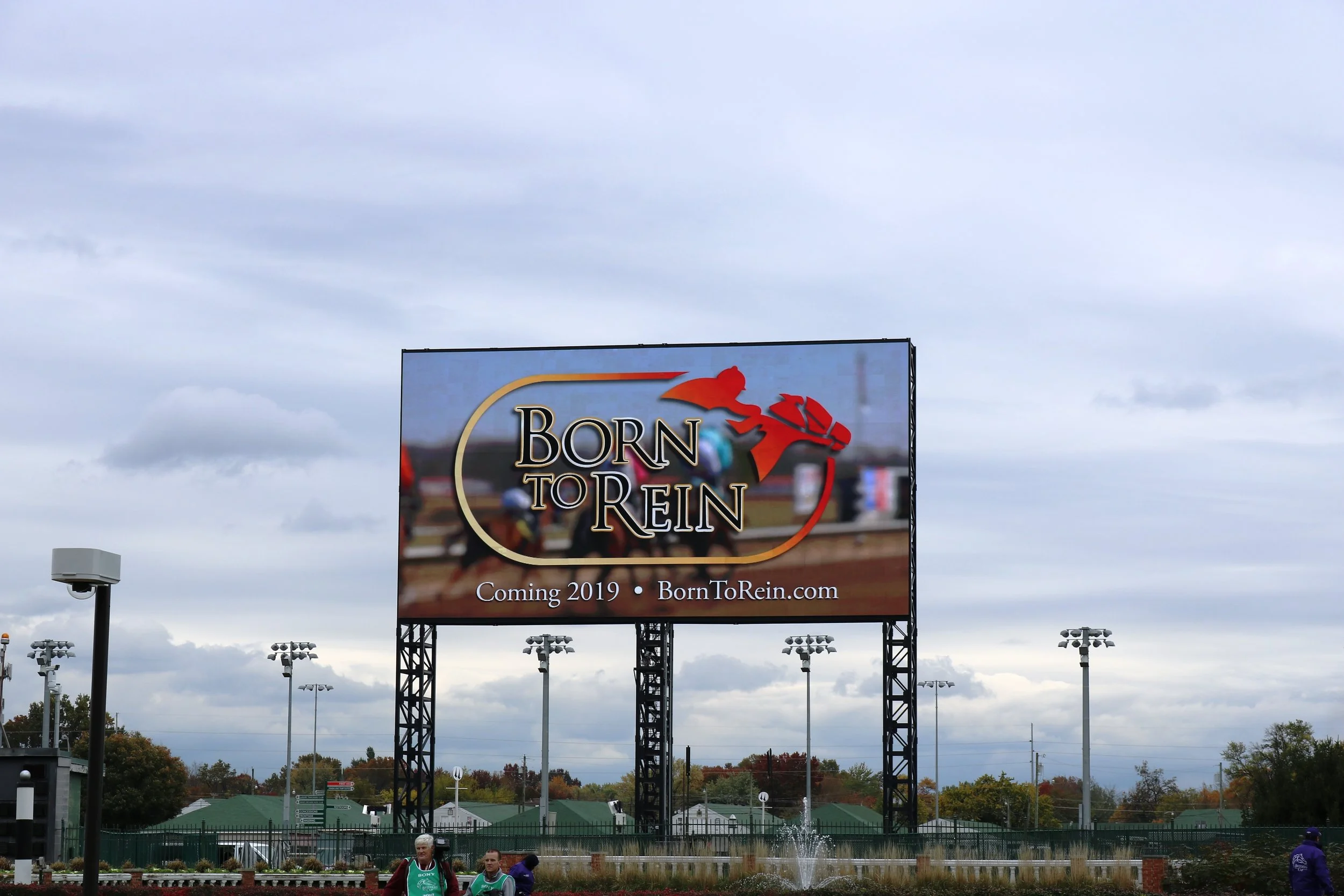 a :30-second commercial of the upcoming documentary film, Born To Rein , was played on Churchill Downs' "The Big Board" – the world’s largest 4K video screen in all of sports. Born To Rein honors Minatare, Nebraska native, John A. Nerud -- who was instrumental in co-founding the Breeders' Cup and served as its inaugural marketing committee chairman -- along with fellow Nebraskans, father-and-son trainers, Marion and Jack Van Berg of Columbus.