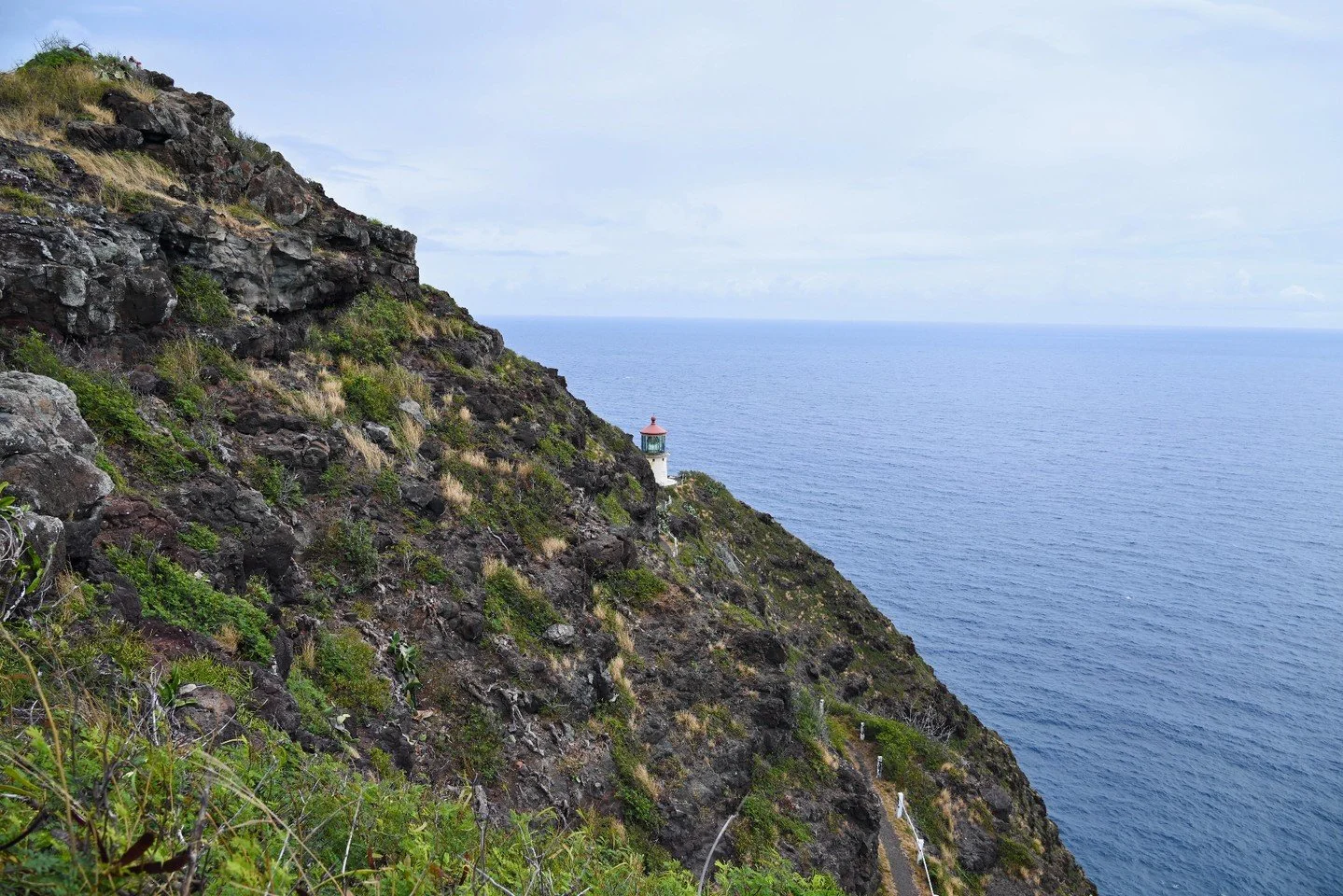 Makapuʻu Point Lighthouse Trail is one of the best &ldquo;big views, low effort&rdquo; hikes on Oahu. 
This fully paved trail on the island&rsquo;s southeast coast leads to sweeping ocean views, rugged cliffs, and a historic red-roofed lighthouse per
