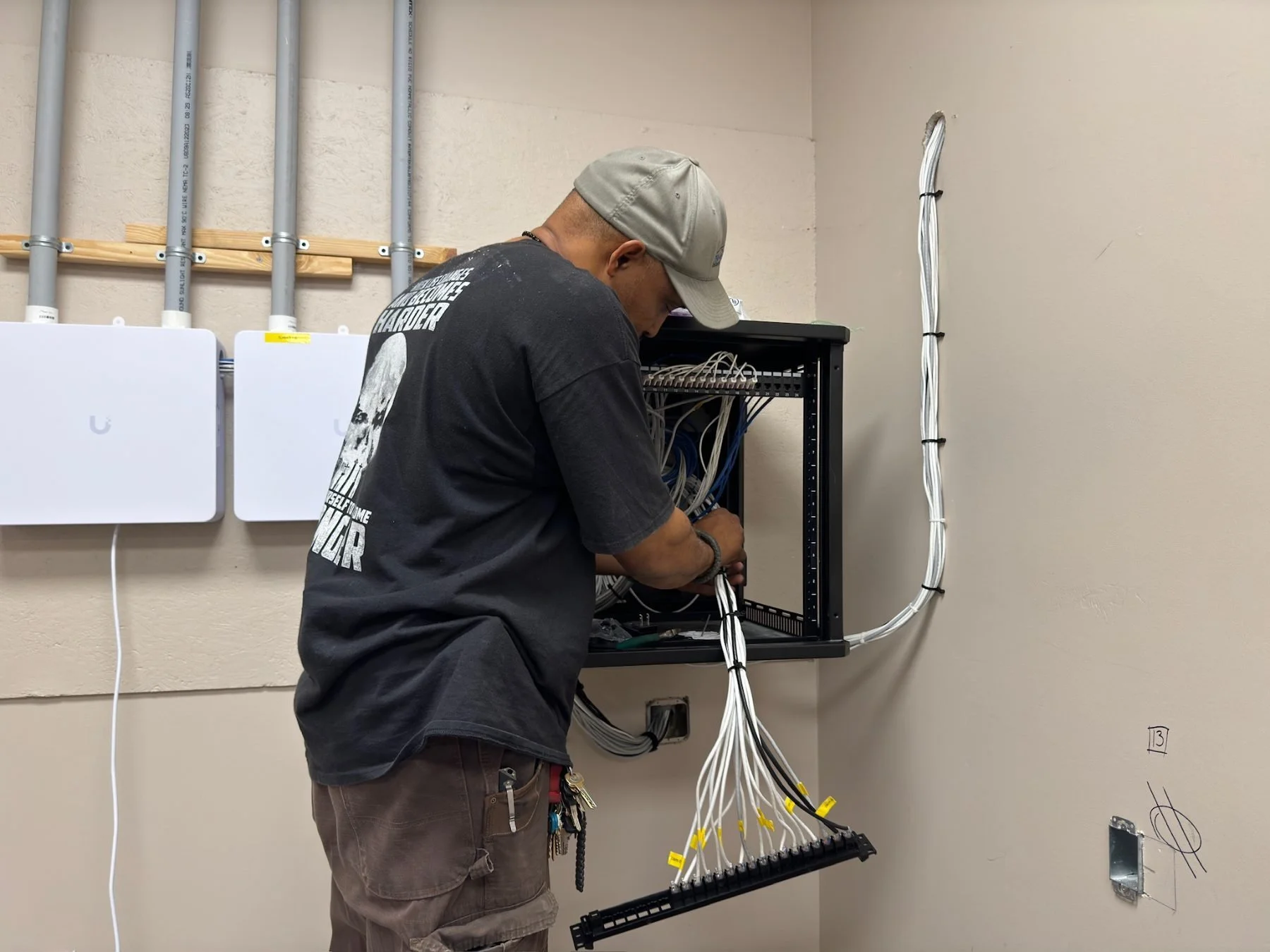 BBS technician terminating network cabling in a client's wall-mounted rack