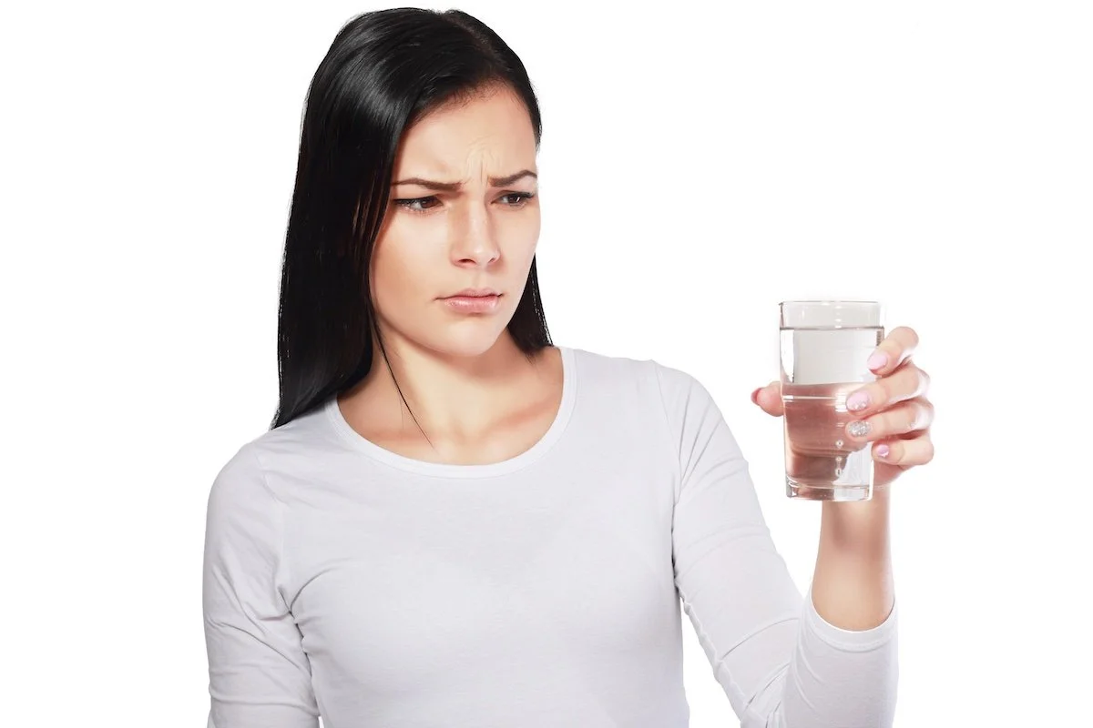 Concerned homeowner tasting tap water