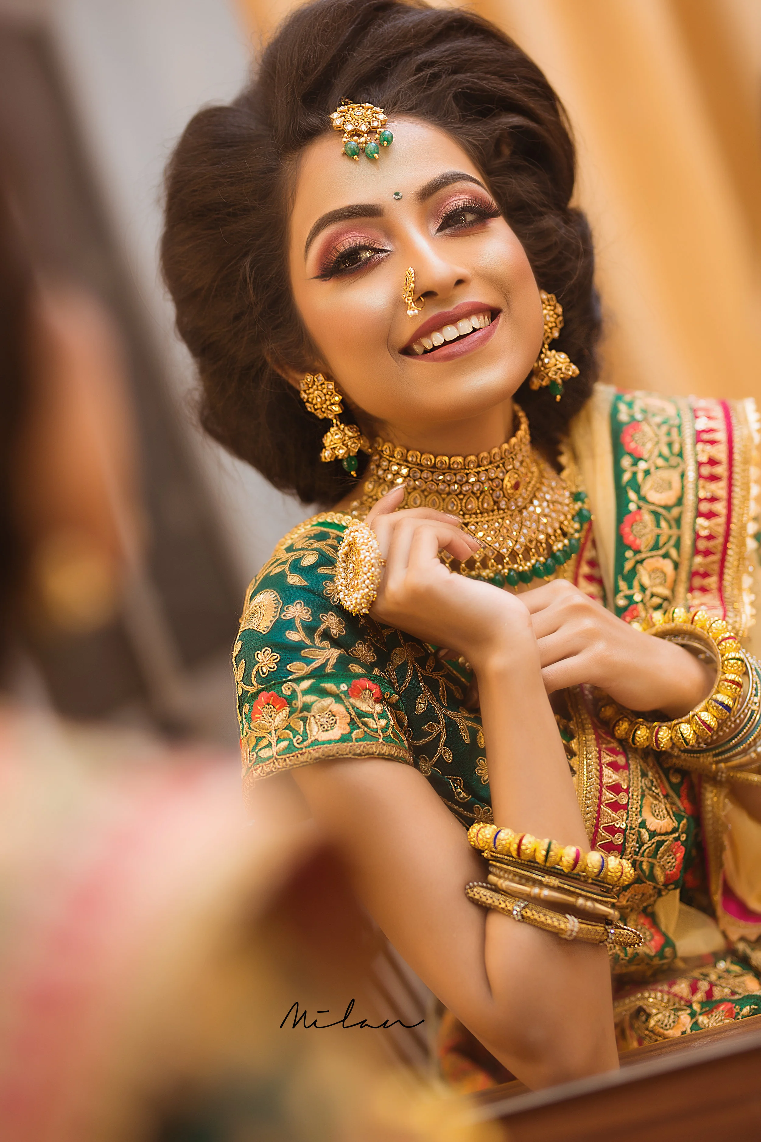 A woman in traditional Indian attire and jewelry smiling during a celebration.