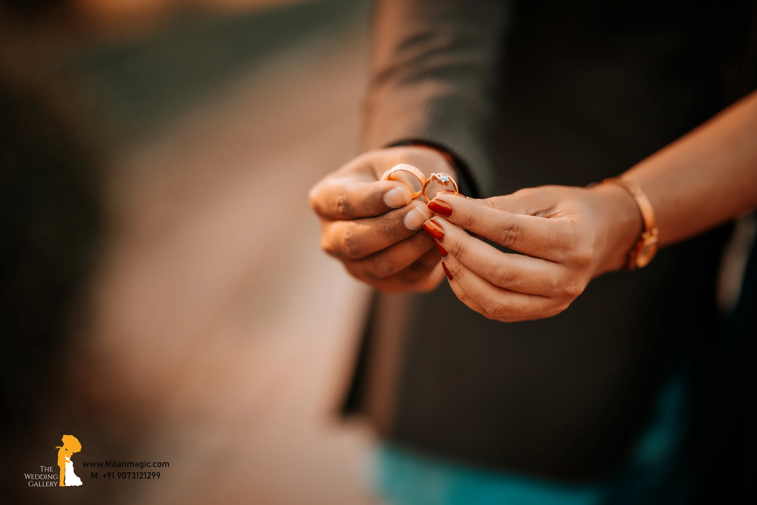 Close-up of a person holding two wedding rings, one with a small diamond, during a wedding ceremony.