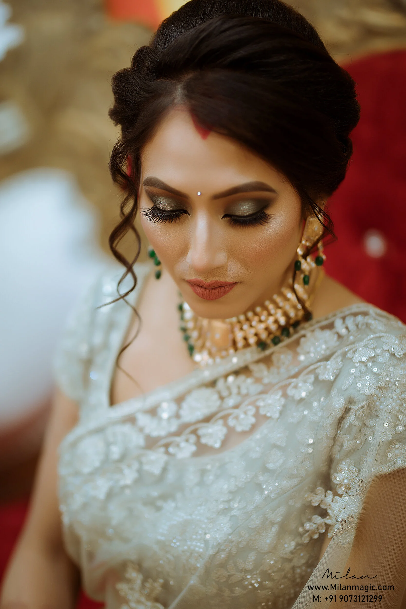 Close-up of a woman with traditional Indian bridal attire, including makeup, jewelry, and a embellished saree, with her eyes closed.