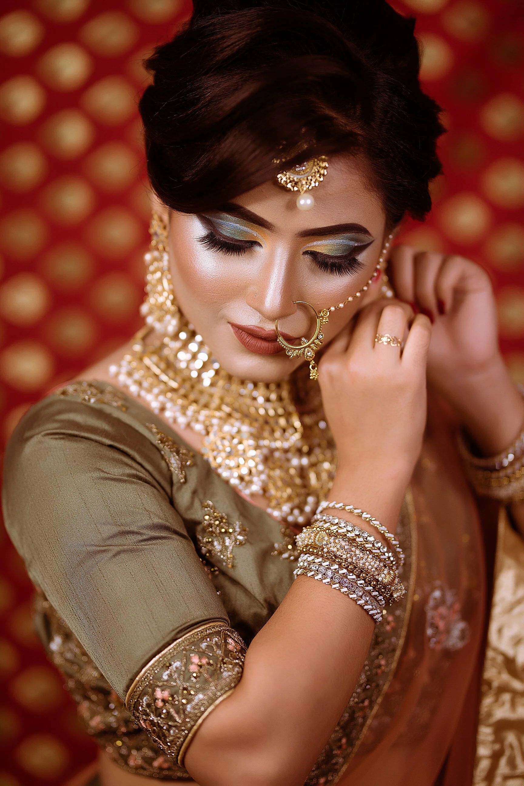 A woman dressed in traditional Indian attire adorned with gold and silver jewelry.