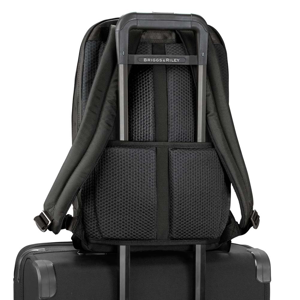 black backpack attached to carry on bag handle