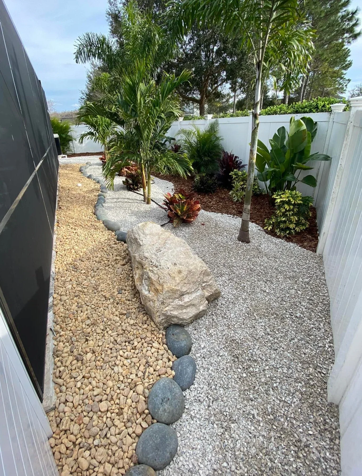 rlc-palms-and-tropical-plants-beside-a-screened-enclosure-with.webp