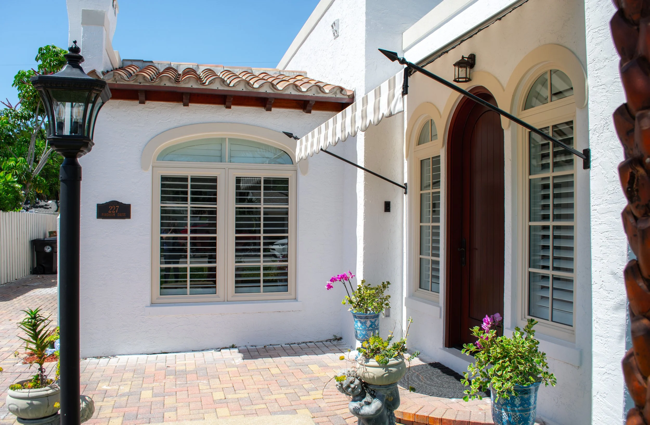 Exterior angle of the 227 Fordham home showing the property facade, roofline, windows, and surrounding outdoor area.