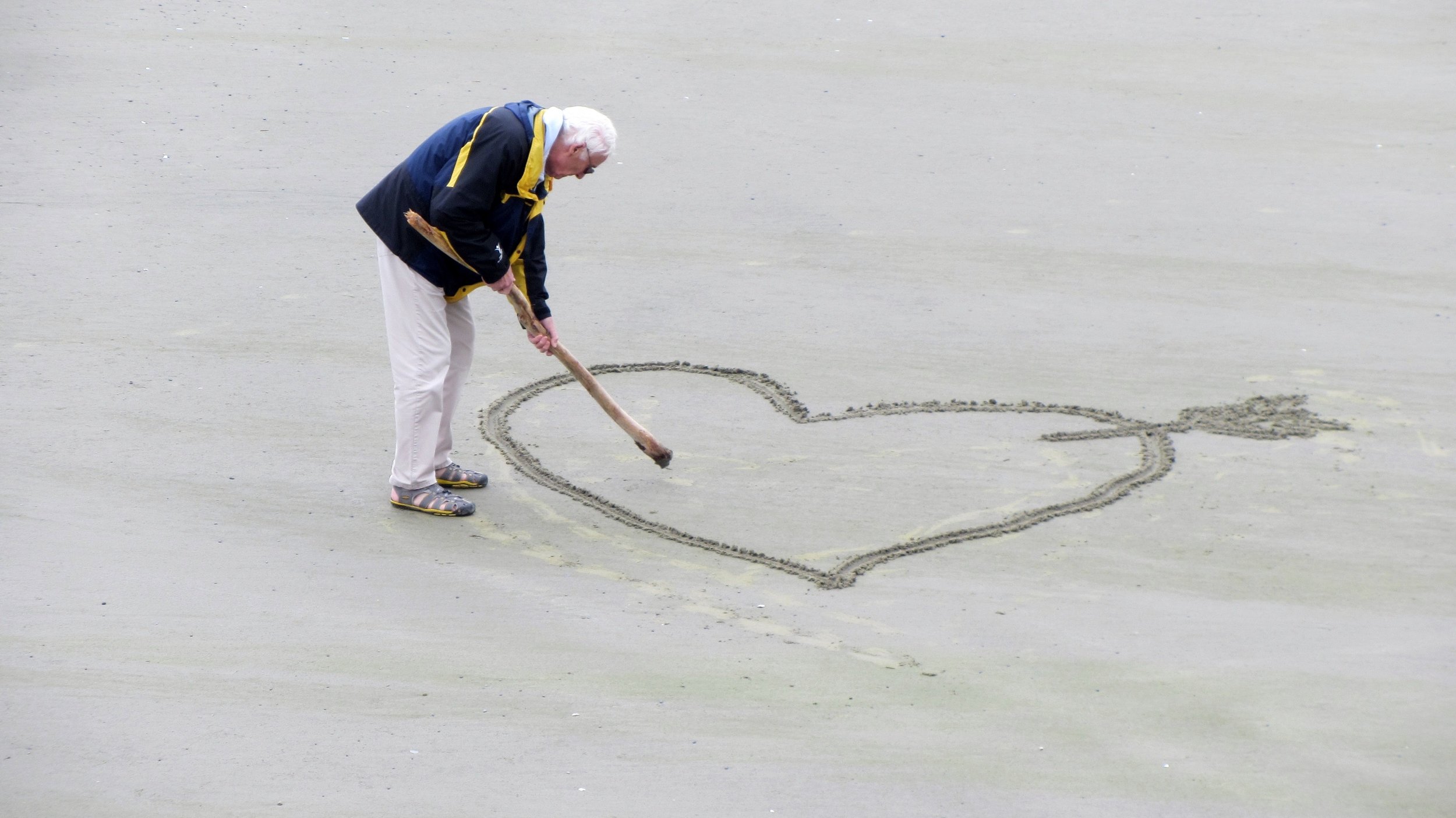 Woman drawing a heart in the sand