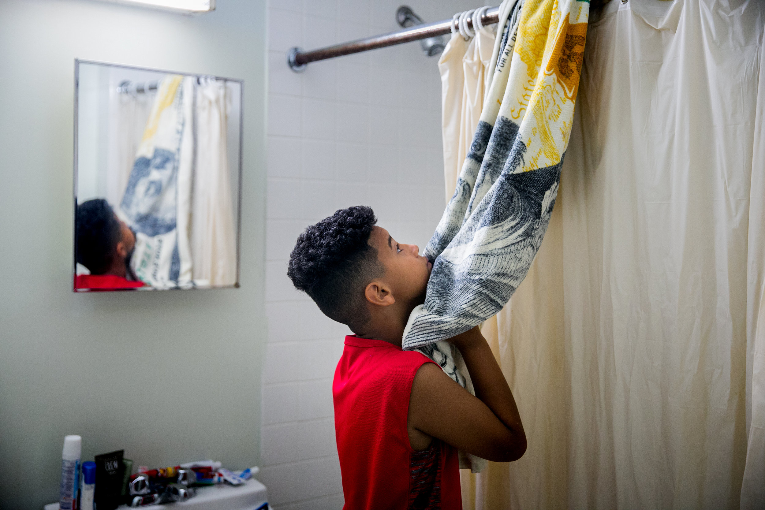  Pedro Cordero Jr. prepares for his day inside the room he shares with his father Pedro Cordero at a homeless shelter in Brooklyn, New York 