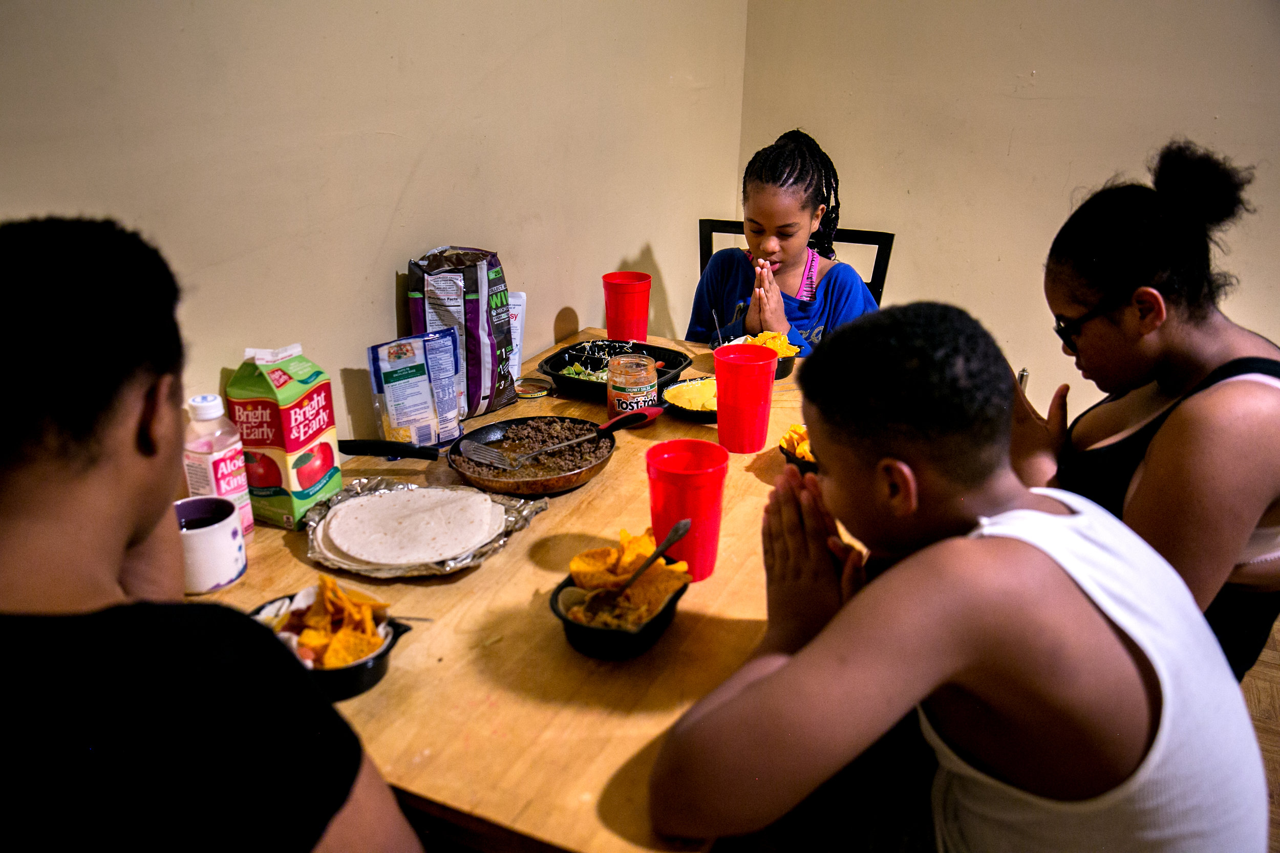  Shantae Young and her children Julian, Shaira and Shayla, say grace before eating dinner inside the shelter they're living in temporarily in the Bronx, New York. 