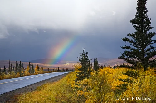 Denali National Park road and rainbow with fall colors.