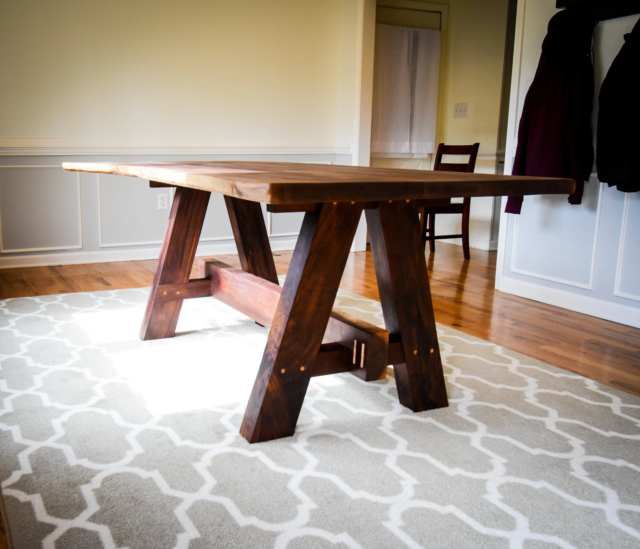 The table top is made from a walnut slab with an additional two walnut boards. Each knot and crack were filled with epoxy. Each crack has a circular oak inlay in place to stop it from spreading further down the top.