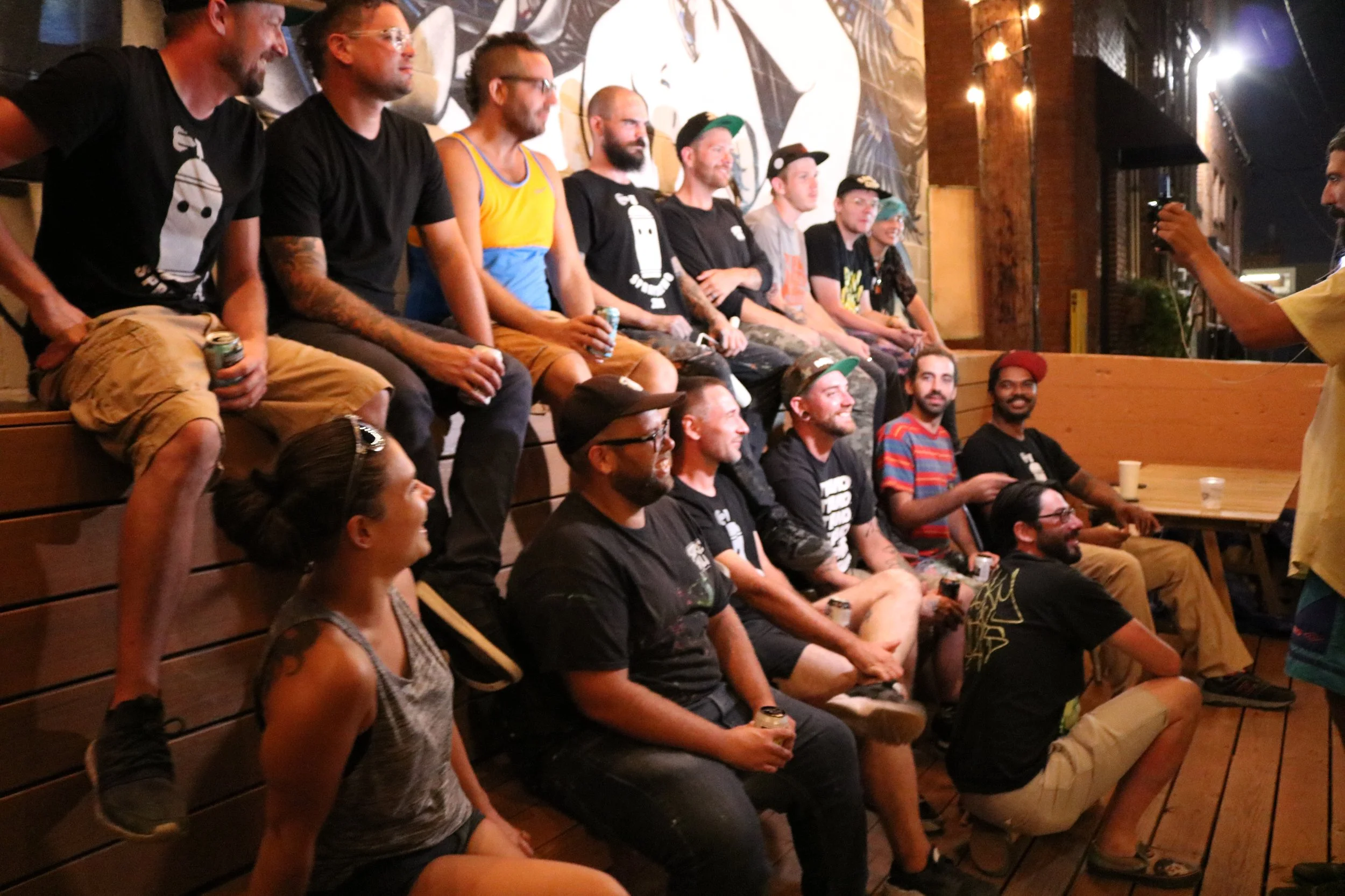  2018 Festival Participants Posing for a group picture taken by Sheppa in front of the mural.  Photo by Diana Gonzalez  