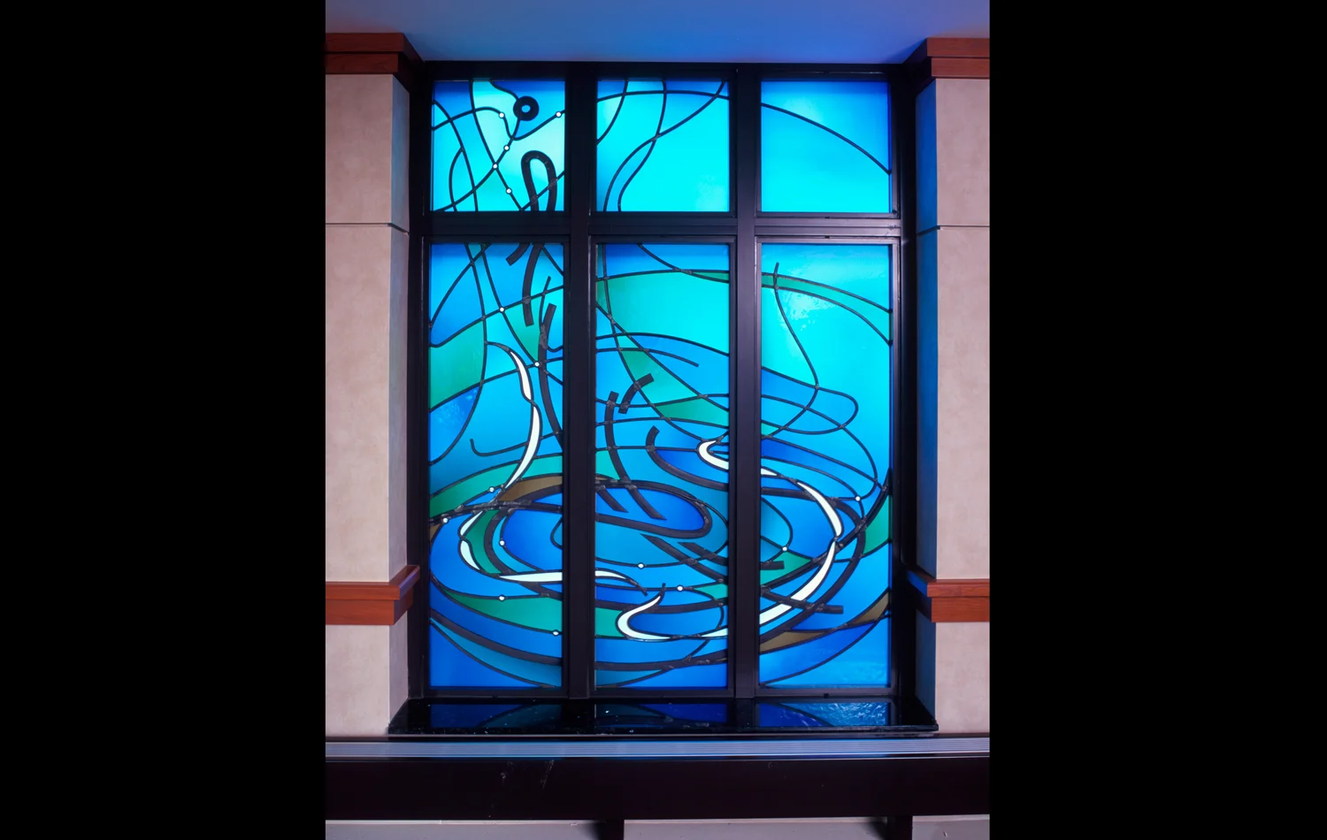 "Water" window: This window represents the concept of water, with all its connotations of abundance, cleansing, flood, and rebirth. As these ideas guided the rhythm and flow of the design, a single water drop emerged. It communicates that we may be one drop in the sea of life, but that God treasures us as a most precious individual, selectively nurturing us in our time of need. 
