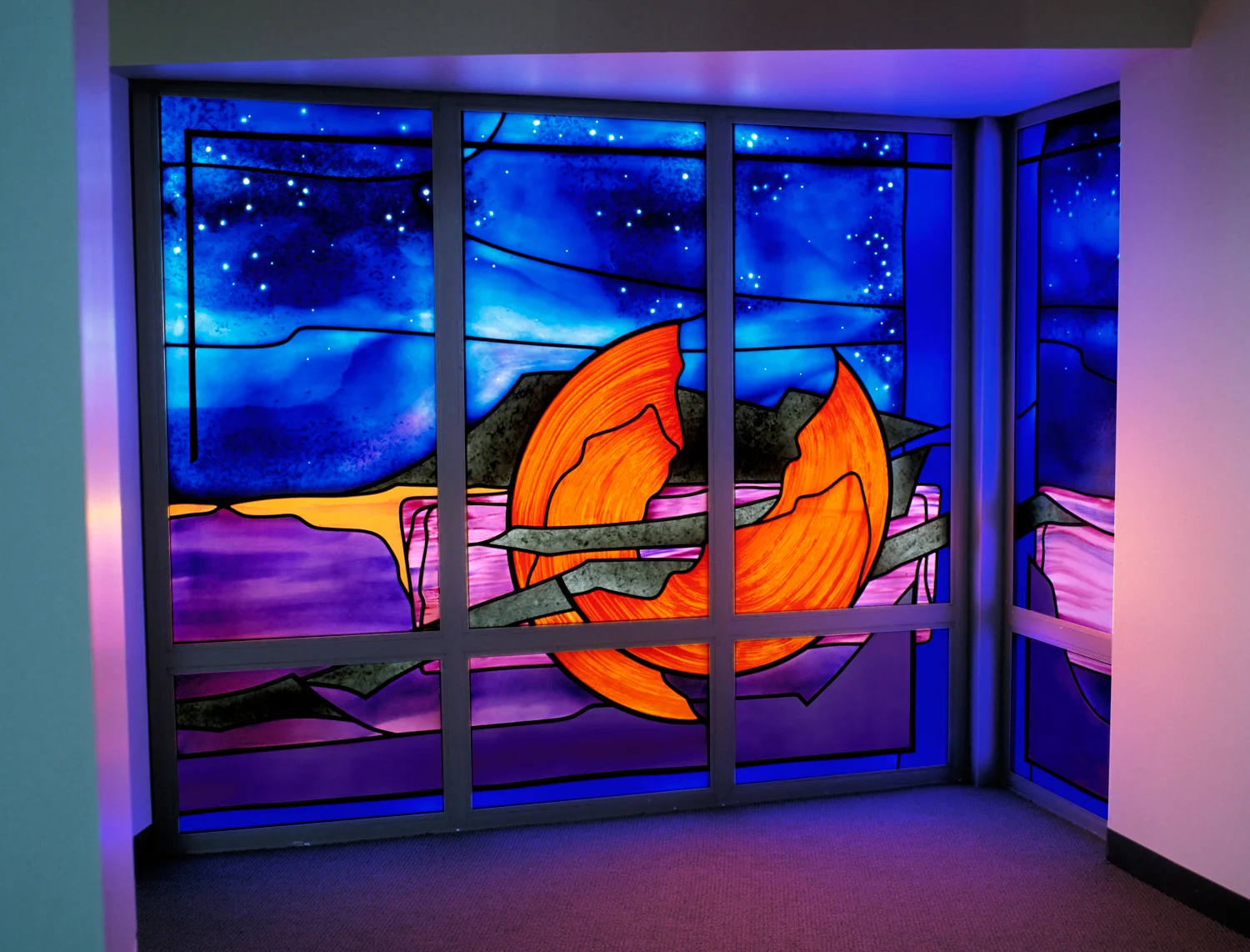 "Broken Sun / Broken Son" Merit Award, Religious Art Awards- American Institute of Architects Size: 7'-0" x 11'-0" Along the perimeter of the main sanctuary is the Ambulatory Walk, where the Stations of the Cross are hung. Because of the proximity of the Ambulatory Window to the Stations, it symbolizes “broken sun, broken Son,” Christ’s somber journey of conflict and resolution. The horizontal flow of the design carries the eye through the window, suggesting that the journey does not stop there, the yellow glass pointing the way towards the Resurrection. 