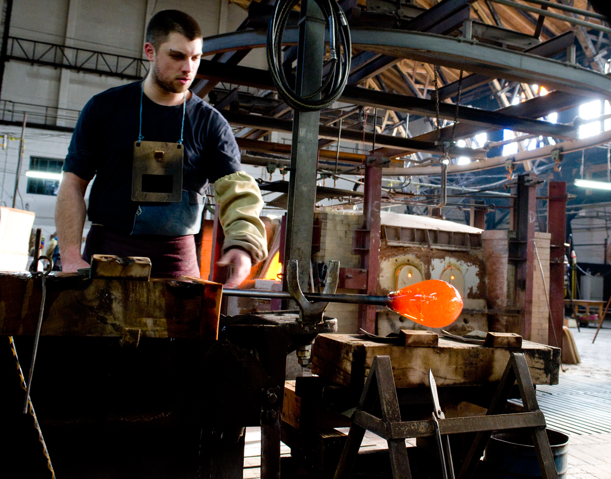 Worker shapes the glass gather into the perfect shape.