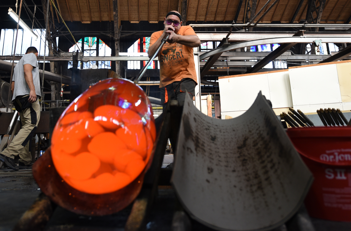 Blowing in a trough gives the glass a cylindrical shape.