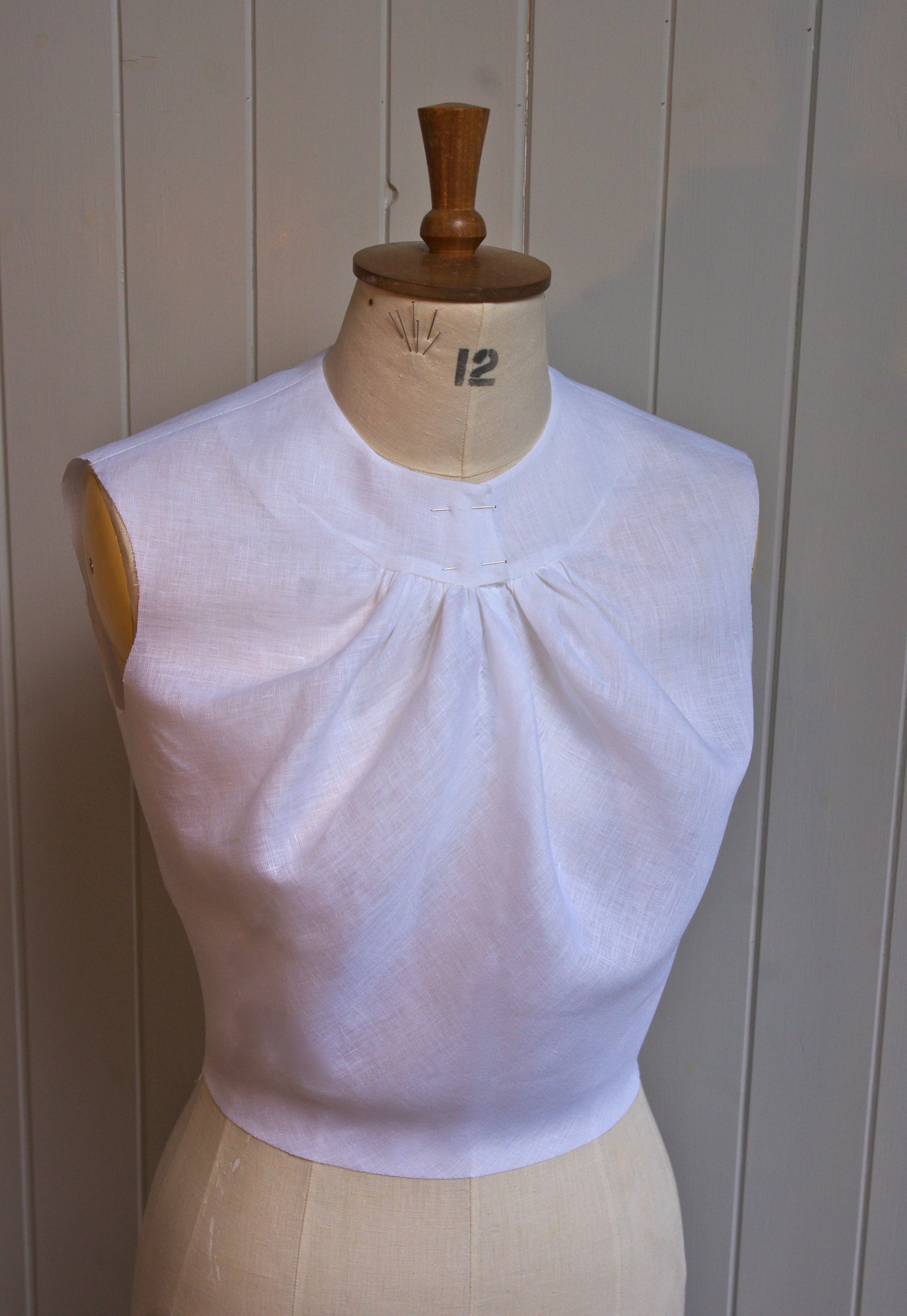 The bodice has a curved neck dart to give the illusion of a yoke. Bodice darts have been moved into the neck for fullness and cut on the bias to give a soft silhouette.