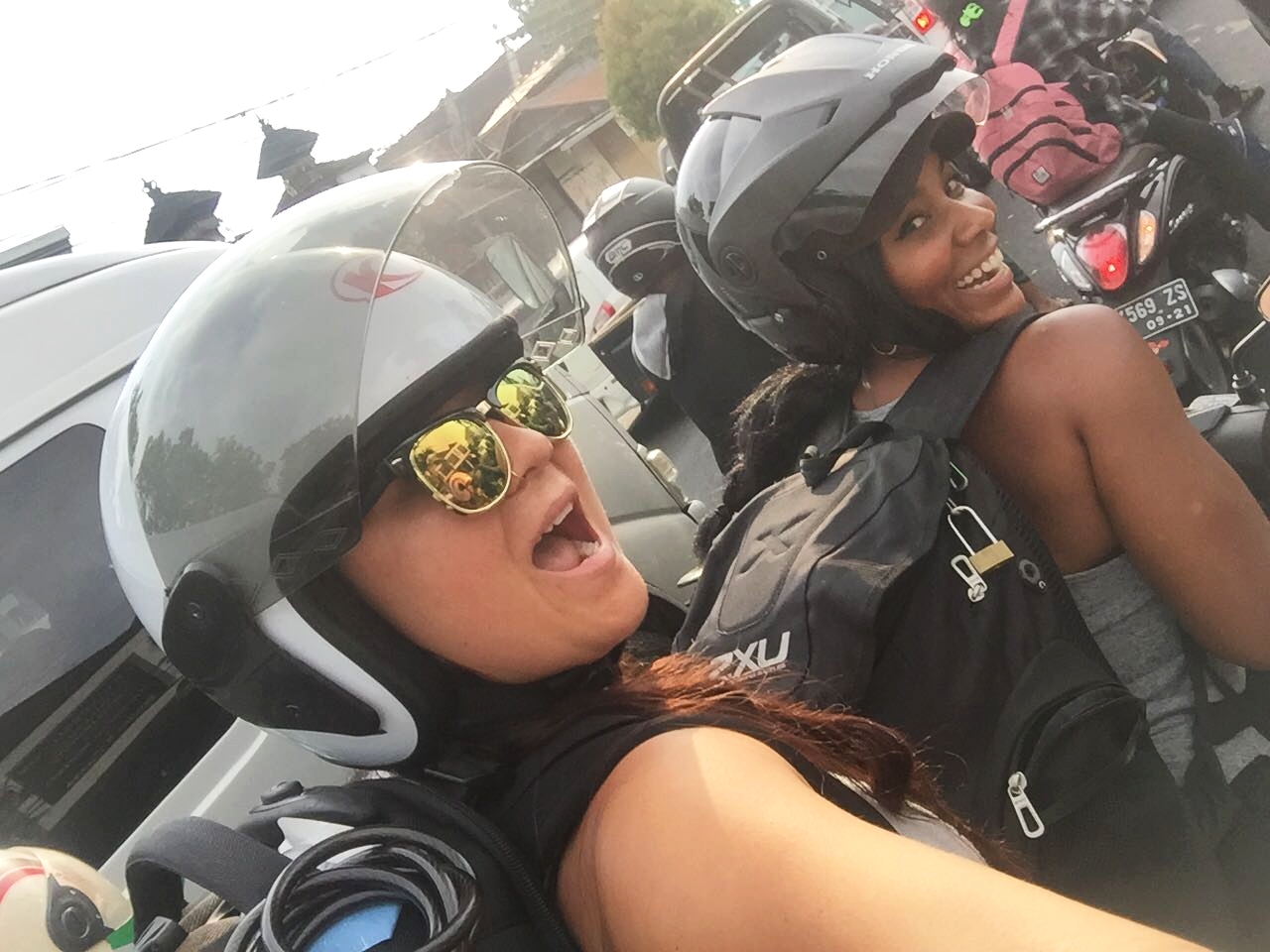 Us in Bali traffic, on a motorbike, with about 50lbs on our back of retreat swag! 