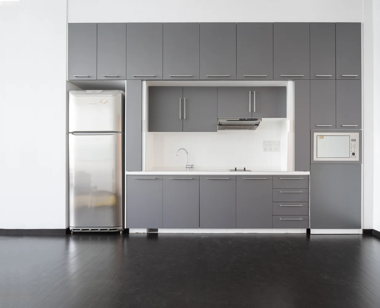 The pantry or kitchenette on the right of the entrance, complete with a fridge, sink, hob and hood for light cooking.