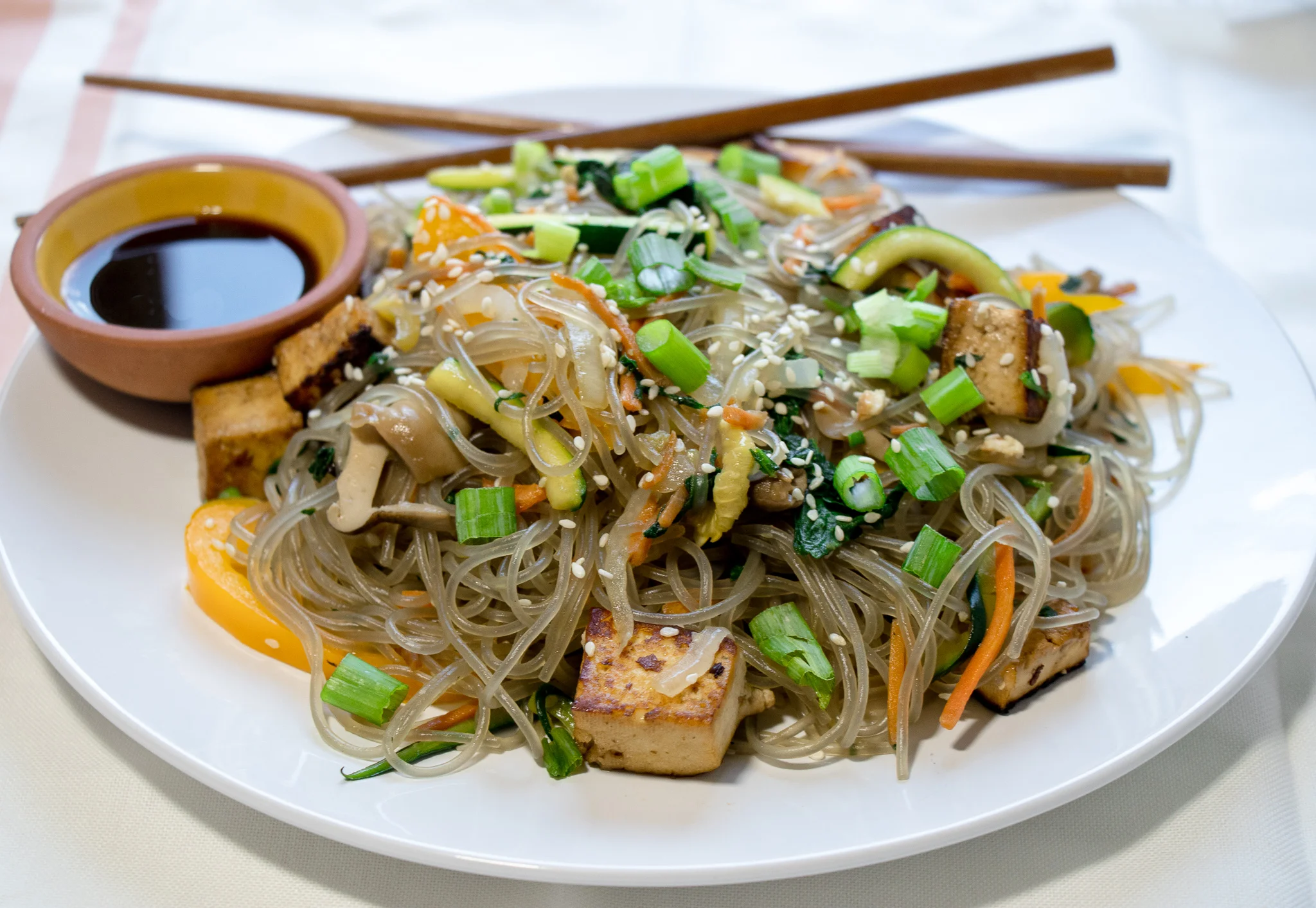 Japchae is a savory Korean noodle dish, made with sweet potato starch noodles. You can easily find these noodles at your local Asian market or online. This dish is pretty quick, and easy, making it a great week night dinner!