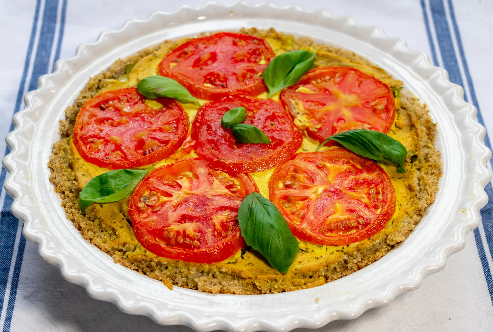 This delicious and beautiful breakfast pie, combines layers of tofu quiche, with roasted tomatoes, and potatoes, all nestled in savory quinoa crust.