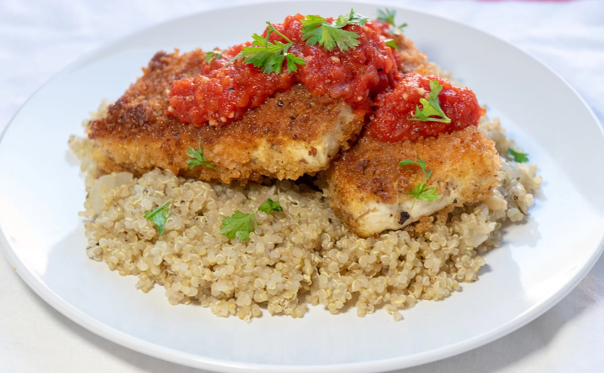 Crispy tofu on a bed of savory quinoa, covered in a delicious red pepper marinara makes for a quick and filling weeknight dinner. You can easily makes this recipe gluten free by using a gf flour blend, and gf panko. You could also use an air fryer to prepare the tofu if you have one, or try baking the tofu pieces if you prefer cooking without oil!