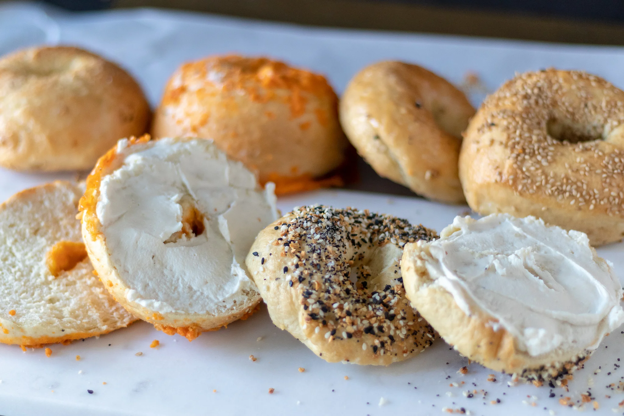 Warm, chewy on the outside, soft on the inside, fresh, homemade bagels! Yes, Yes, and YES! Seriously, y'all, fresh homemade bagels are so easy to make, plus you get to top them with whatever you want! Bagels freeze really well, so make yourself a double batch on the weekend, and next week’s breakfast just got a lot easier, and a whole lot more tasty! If you don’t believe me, I have left photo proof of our two year old digging into a fresh everything bagel that she slyly snatched as we were trying to photograph them. I mean she just did the thing the rest of us wanted to do. But who can blame her. They are that good! And if y’all can’t do gluten, don’t worry! Our friends over at Not That Kind of Vegan took this recipe and turned it gluten free, so go check out their recipe !! Now everyone can have their bagel and eat it too!!