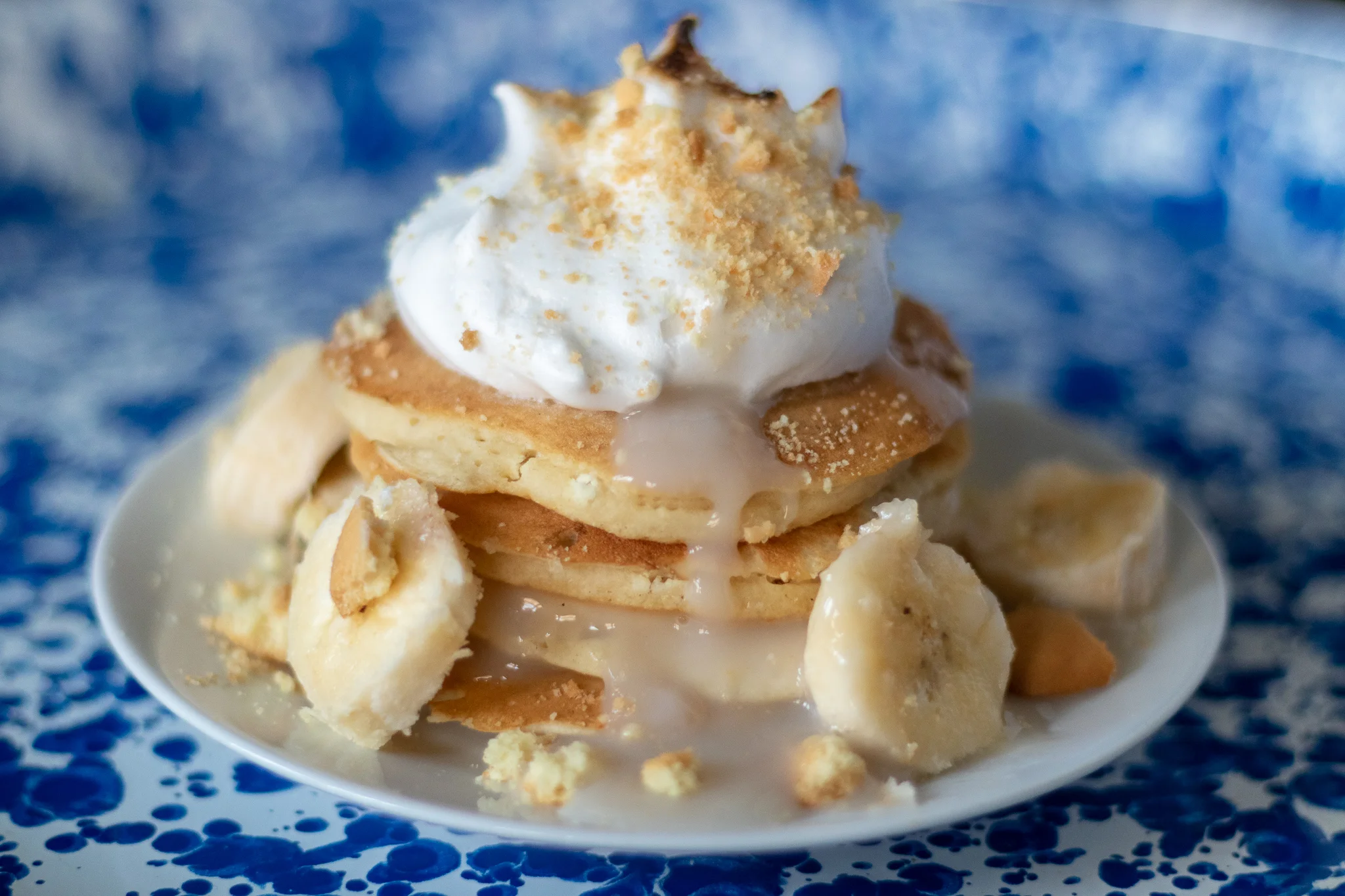 If you are even remotely southern, you have probably had classic banana pudding in your lifetime. Sweet vanilla pudding, sliced bananas, vanilla wafter cookies, topped with the most perfect, light and fluffy, golden brown peeked meringue! It’s a work of art and a thing of beauty. I dream about banana pudding at night. So what is one to do when they can’t wait for dessert? You turn your favorite dessert into breakfast, obviously! So may I introduce you to the vegan banana pudding pancakes! Perfectly fluffy pancakes, vanilla pudding, bananas, crushed vegan vanilla wafers. and sweet aquafaba meringue! I can not think of a better way to start my day than with these pancakes!