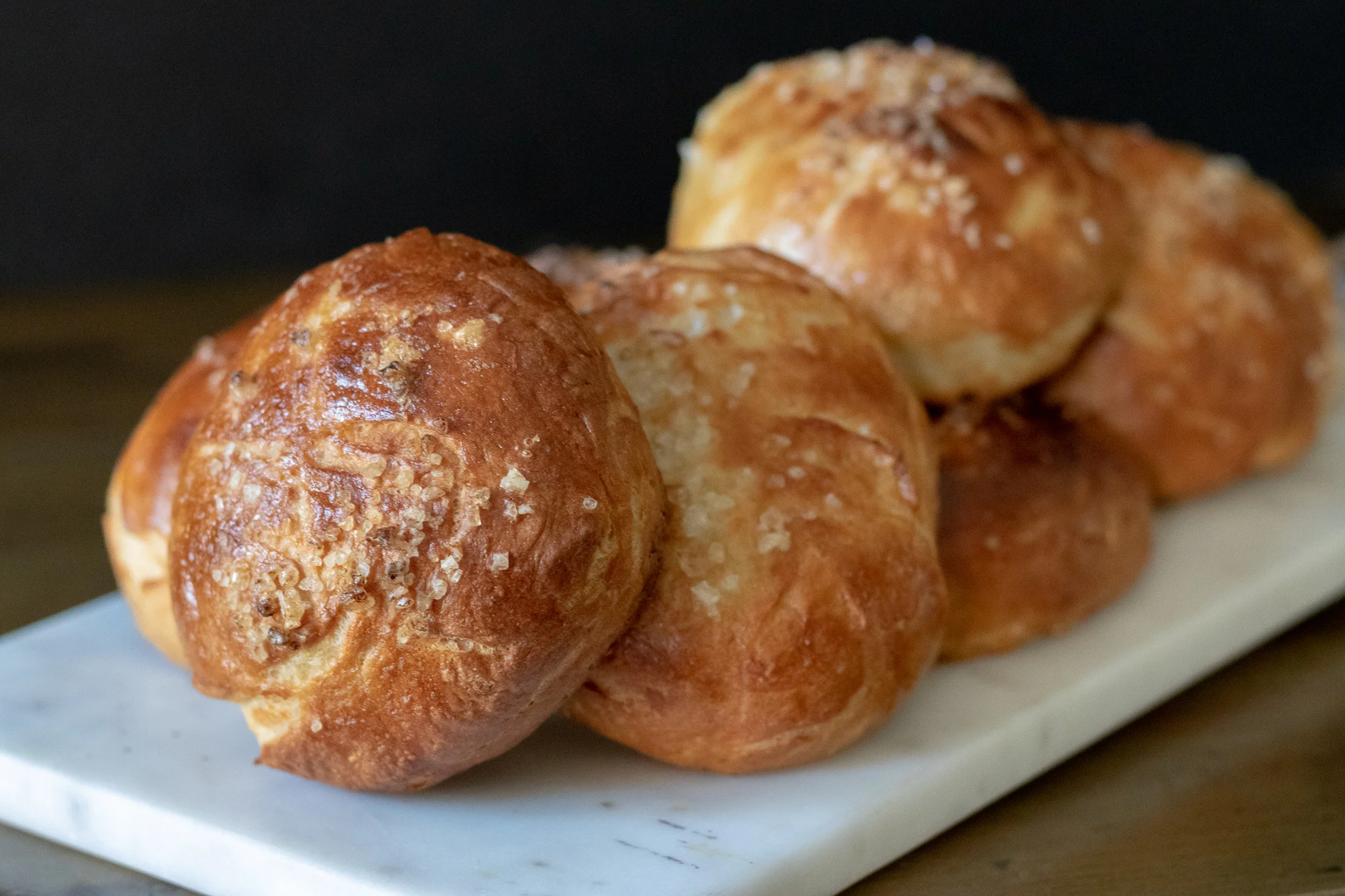 What’s better than a delicious vegan soft pretzel!?!? Well, maybe a delicious soft vegan pretzel bun! I mean come on! Who doesn’t want a tasty plant based burger on a homemade pretzel bun? We use our original Challah Y’all, Vegan Challah dough to make these super tasty buns and they are just about perfect. Soft and chewy on the inside, crisp and salty on the outside! Everything a pretzel bun should be, plus they vegan!!