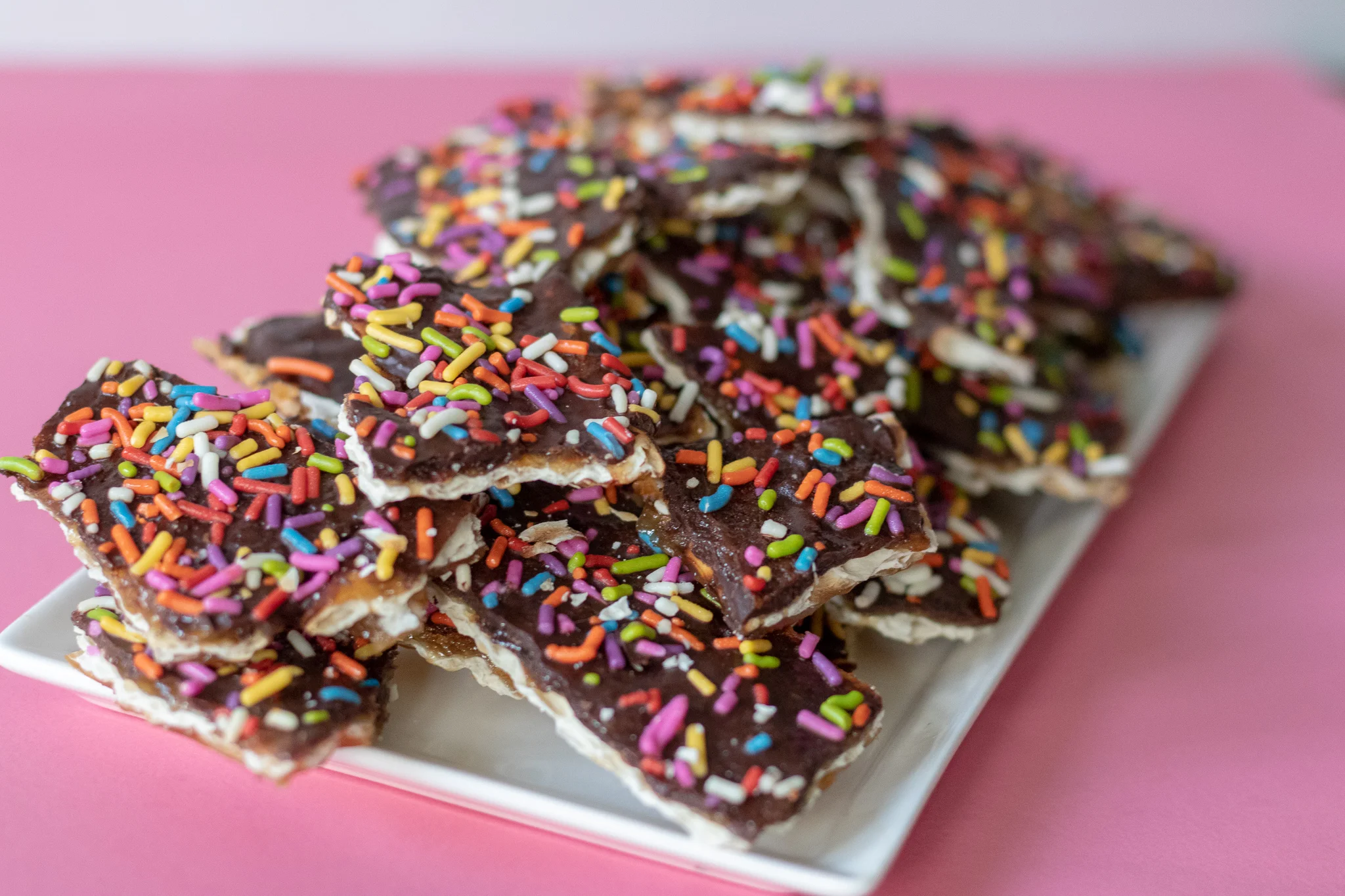 If you celebrate Passover then you probably already know all about matzah toffee, otherwise known as matzah crack. I mean if you have to eat matzah for a week, you gotta get creative! I don’t hate matzah. I am however 100% over eating it after a week. I don’t hate it, lets say I tolerate it. BUT when you pour butter, sugar, chocolate and sprinkles all over it, I FLIPPING LOVE IT! Suddenly Passover is the best time of year. So much for feeling afflicted! You may have also had something like this made with saltine crackers, but I promise, PROMISE, it is better on thin, crispy, light matzah! So even if you do not celebrate passover, you can still grab a box of matzah in the international isle of your local grocery store and make yourself a batch of this yearly favorite. And if you by some chance get invited to a Passover Seder, now you know what to make!