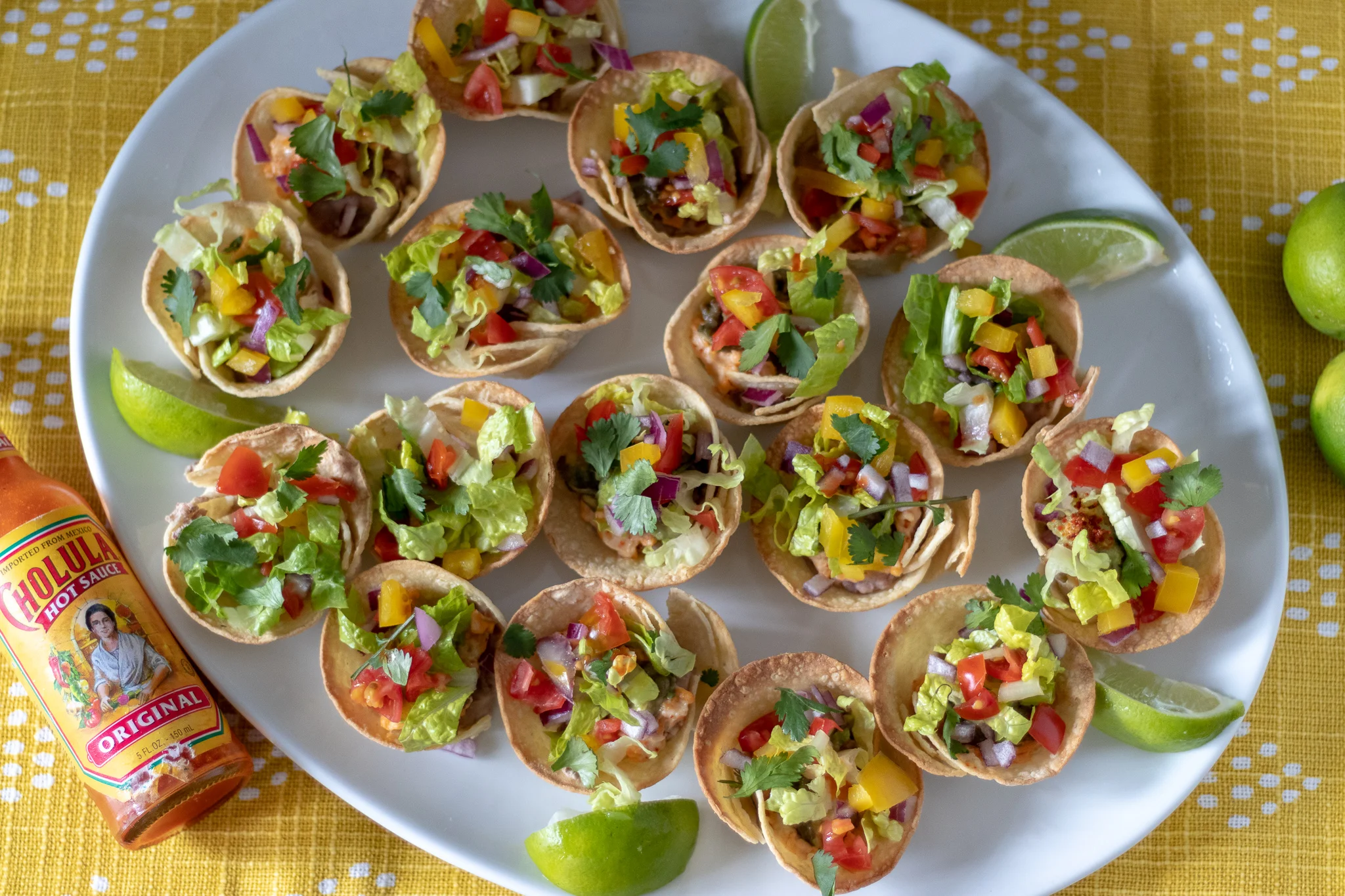 I love party food, and I love to host parties!!! 7 layer taco dip being one of my favorite party foods. I mean it’s a bowl full of all the the most delicious taco-y things all stacked up together! What is not to love there? Recently I found these adorable little street taco tortillas and my oldest daughter suggested we use them to make little taco dip cups. I am so proud of our genius offspring and their brilliant ideas!! We have raised them well!! So as she requested, we made these bitesize vegan taco dip cups! Not only are they super tasty, they are so super cute…I mean if a food can be cute, then I am standing by these being the cutest! Make them for a snack, make them for a party, make them because eating tiny food is normally more fun to eat! I made them for lunch and our family plowed through them! But I am still rooting for another party in the near future to show off these adorable little bites.