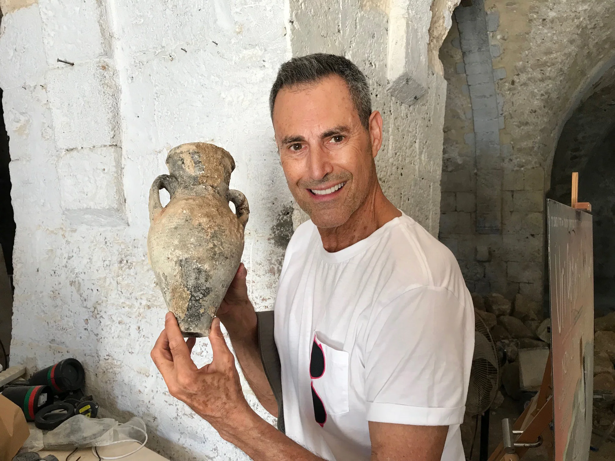 Uri Geller holds a water or oil jug that was discovered during the work in the museum. Photo : Dlila Bar-Ratson