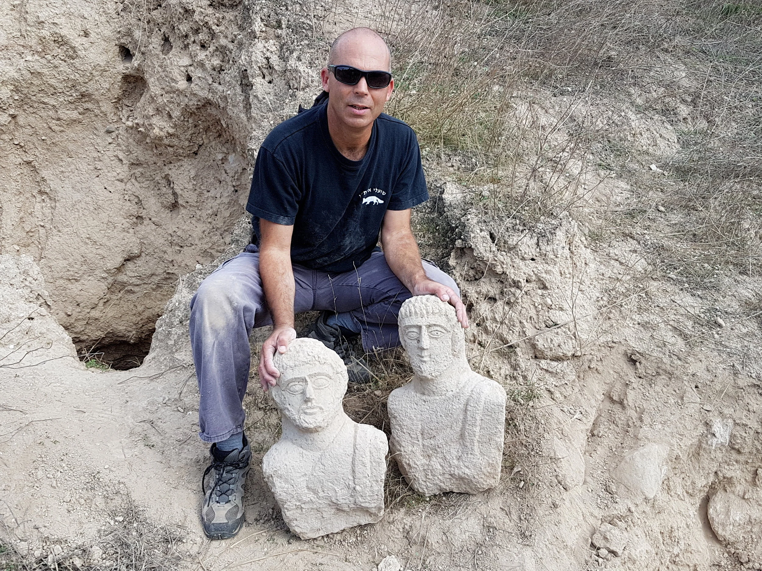 Nir Distelfeld, Israel Antiquities Authority Theft Prevention Unit inspector, with the two busts. Photo: Eitan Klein, Israel Antiquities Authority
