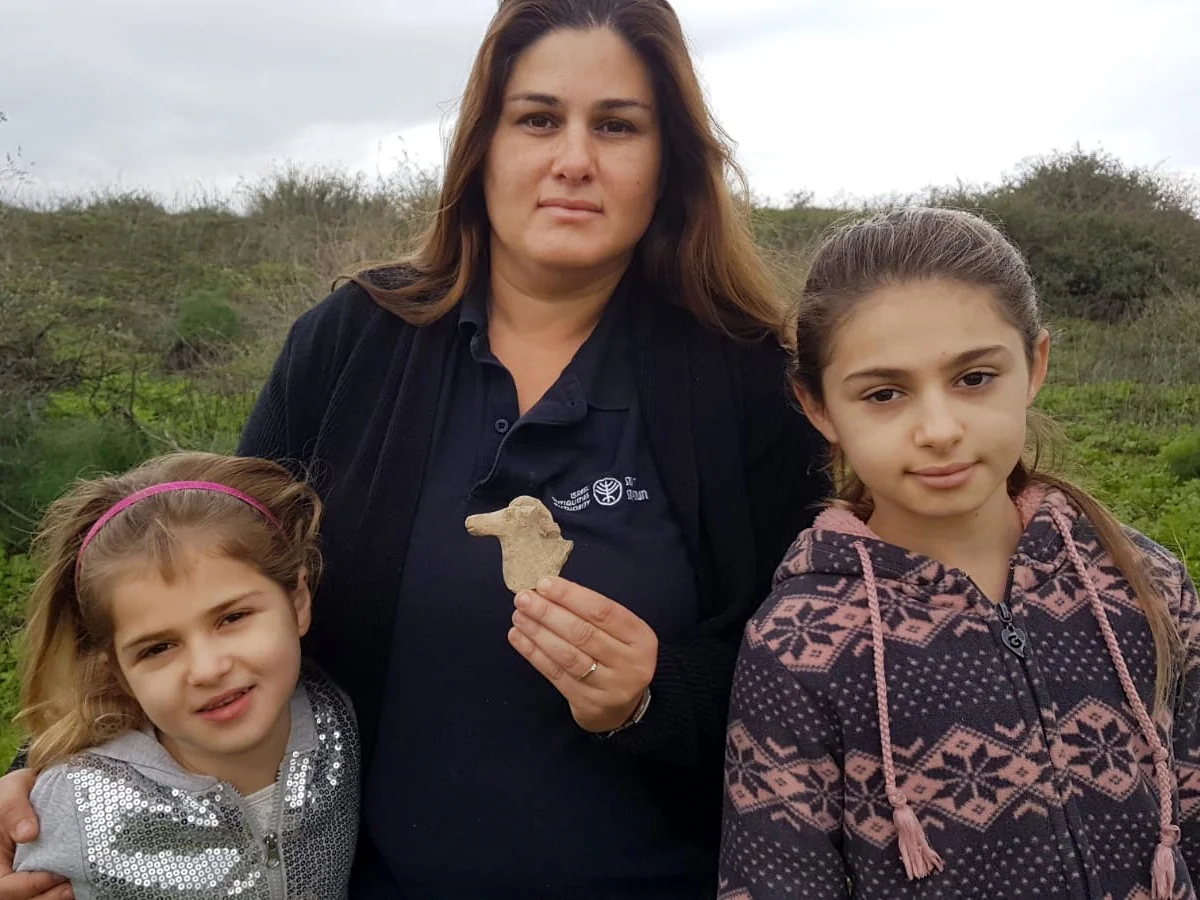 Right to left: Maya, Ayelet and Hadas Goldberg with the horse figurine from the kingdom of Israel found in the Beit She'an Valley. Photo: Nir Distfeld, Israel Antiquities Authority