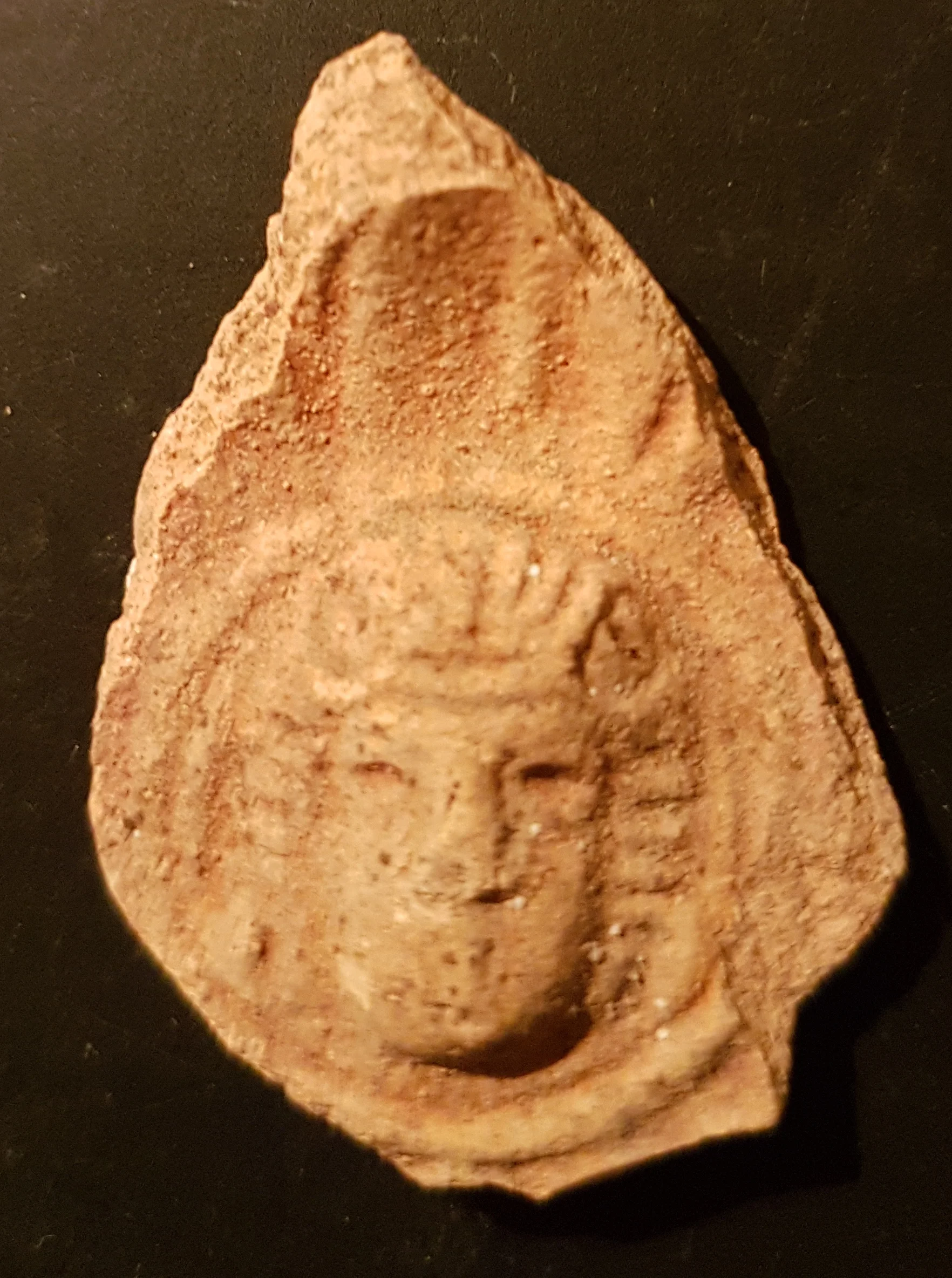 Molded face, possibly of a god, from a Roman oil lamp. Photo: Tali Erickson-Gini, IAA