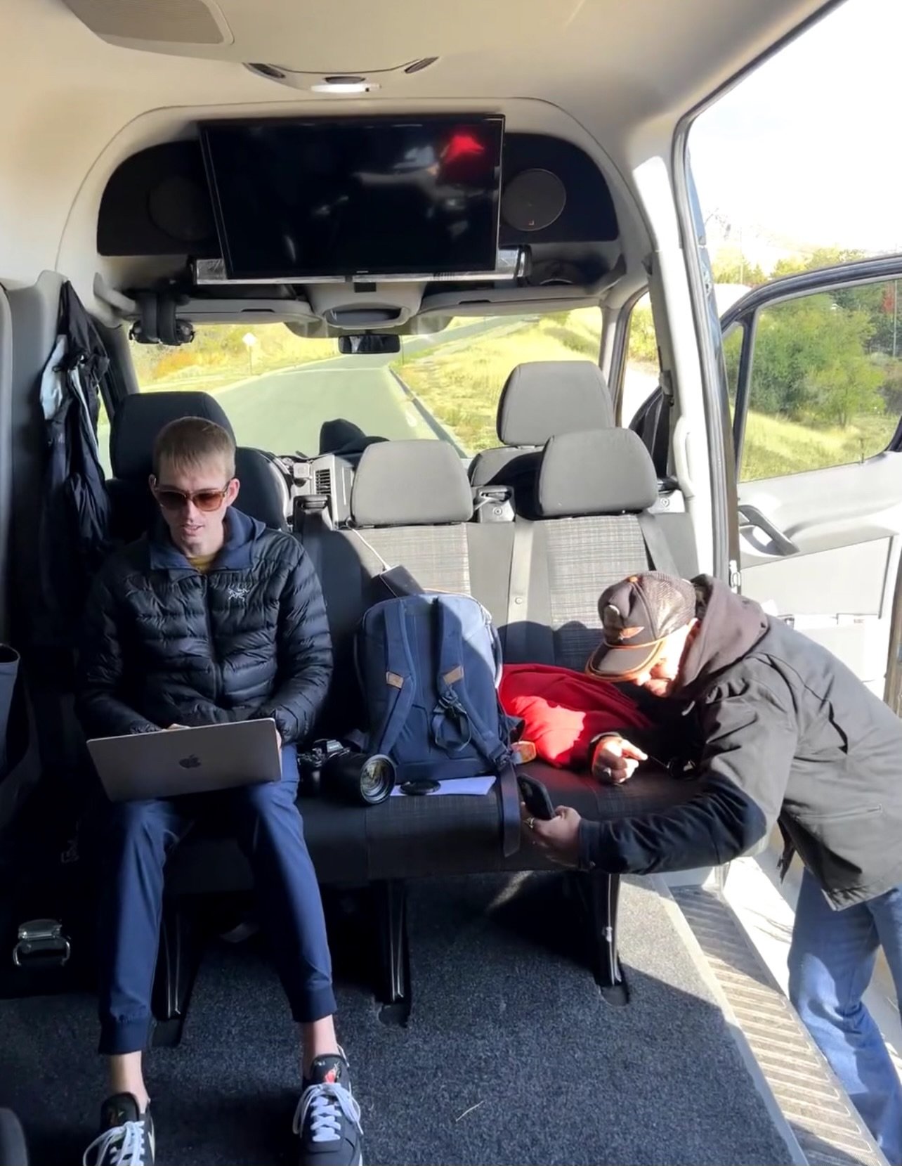 Producer typing on laptop inside van