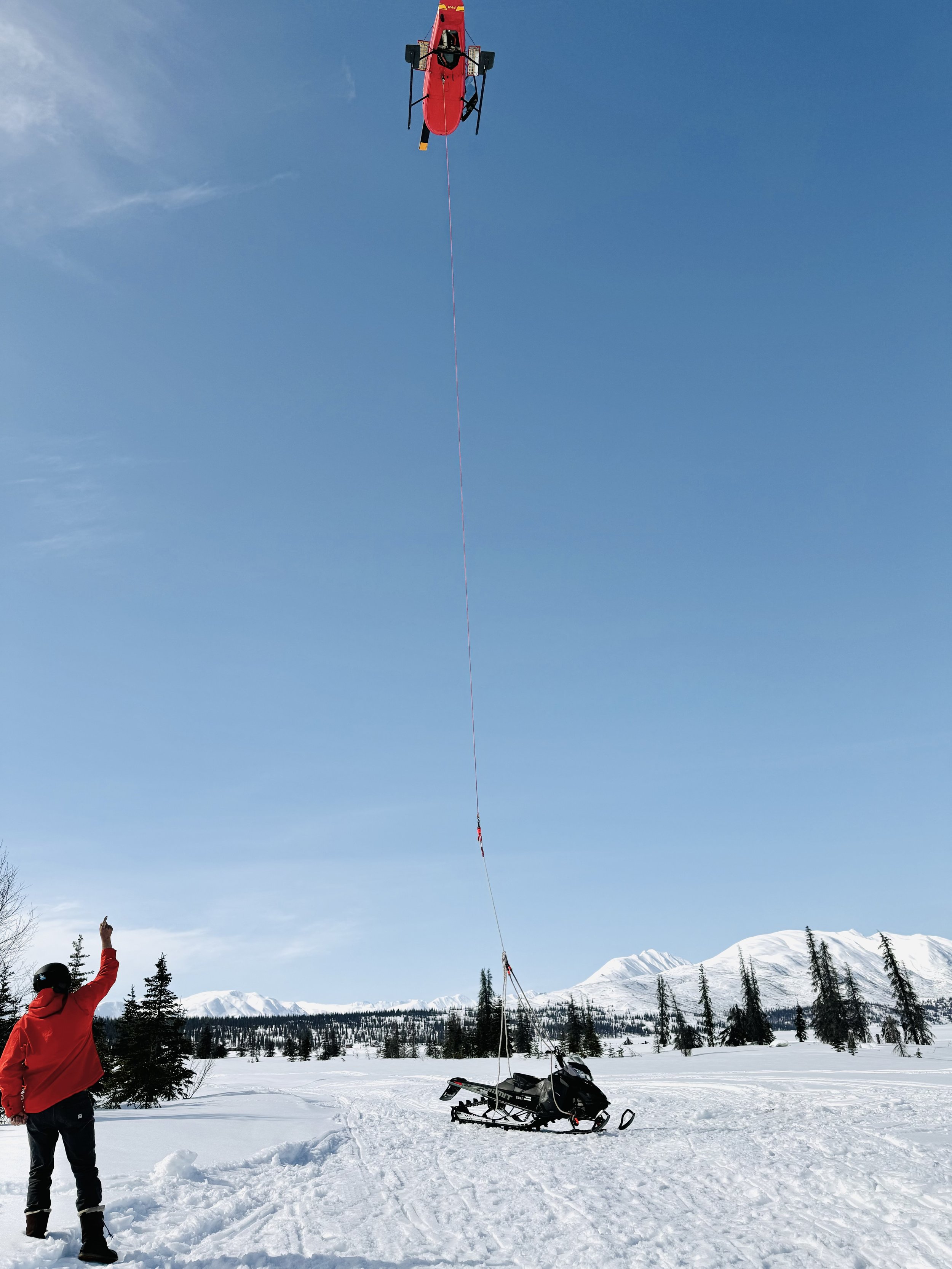 Helicopter prepares to lift snow machine