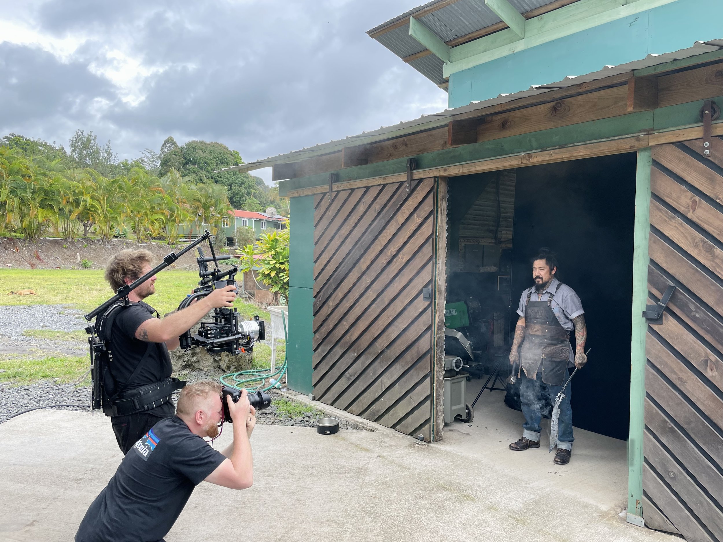 Film crew shoots man working in blacksmith shop