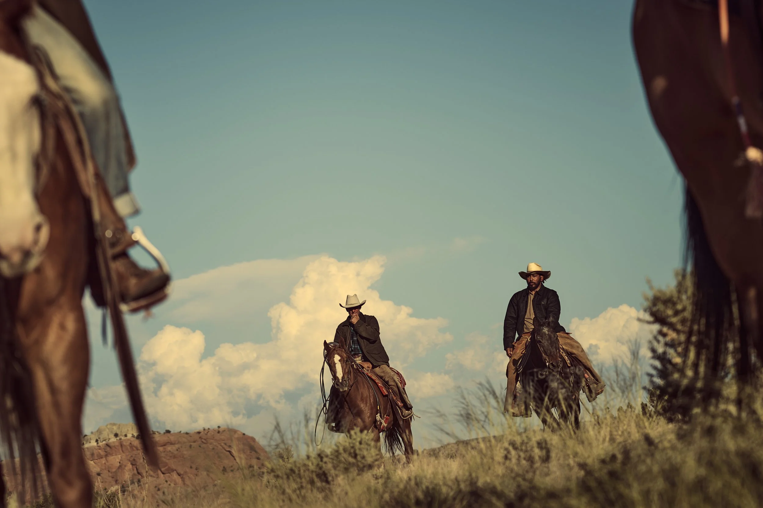 Four cowboys riding in the desert