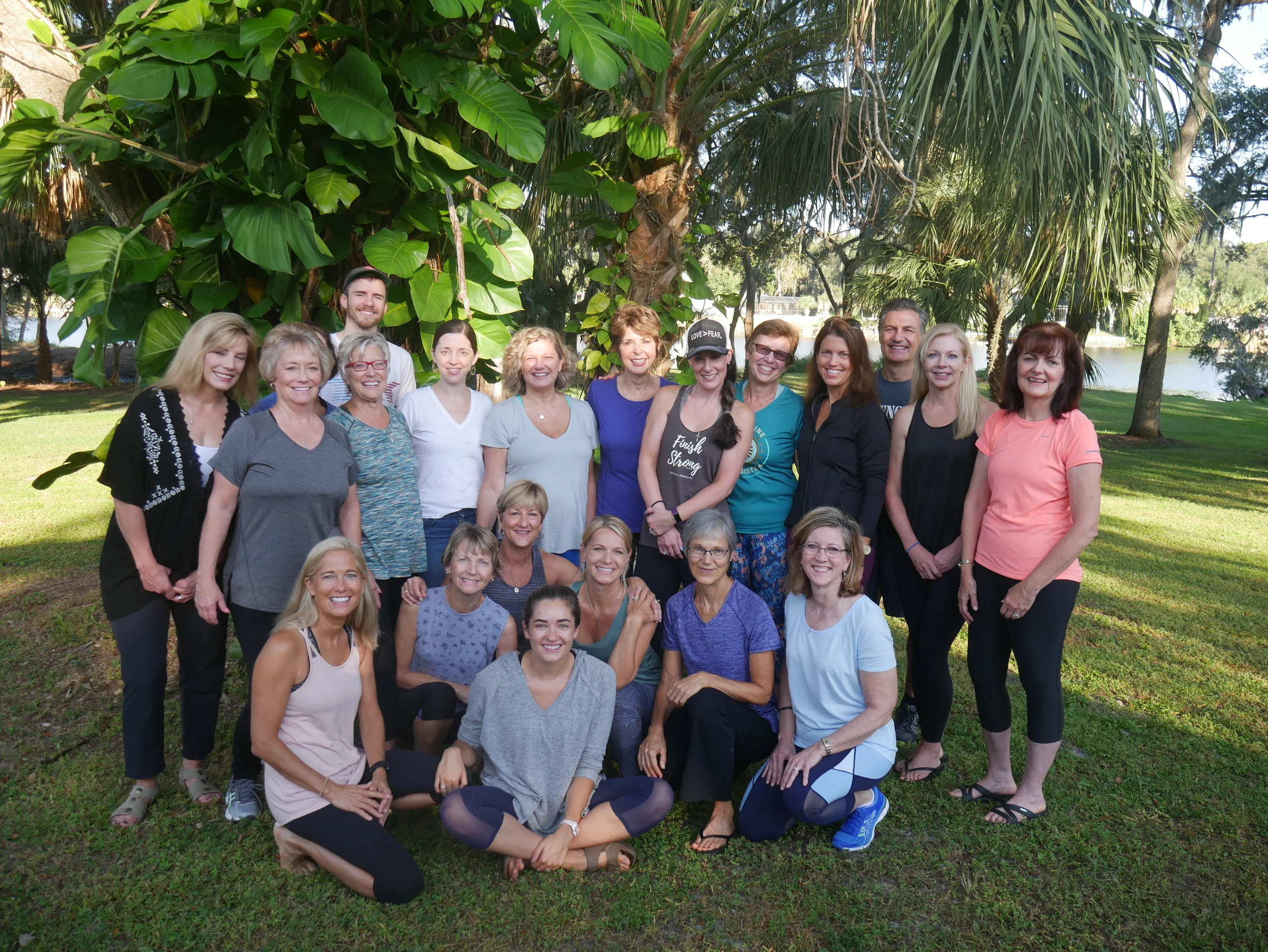 Group-of-people-posing-and-smiling-in-front-of-trees-and-river