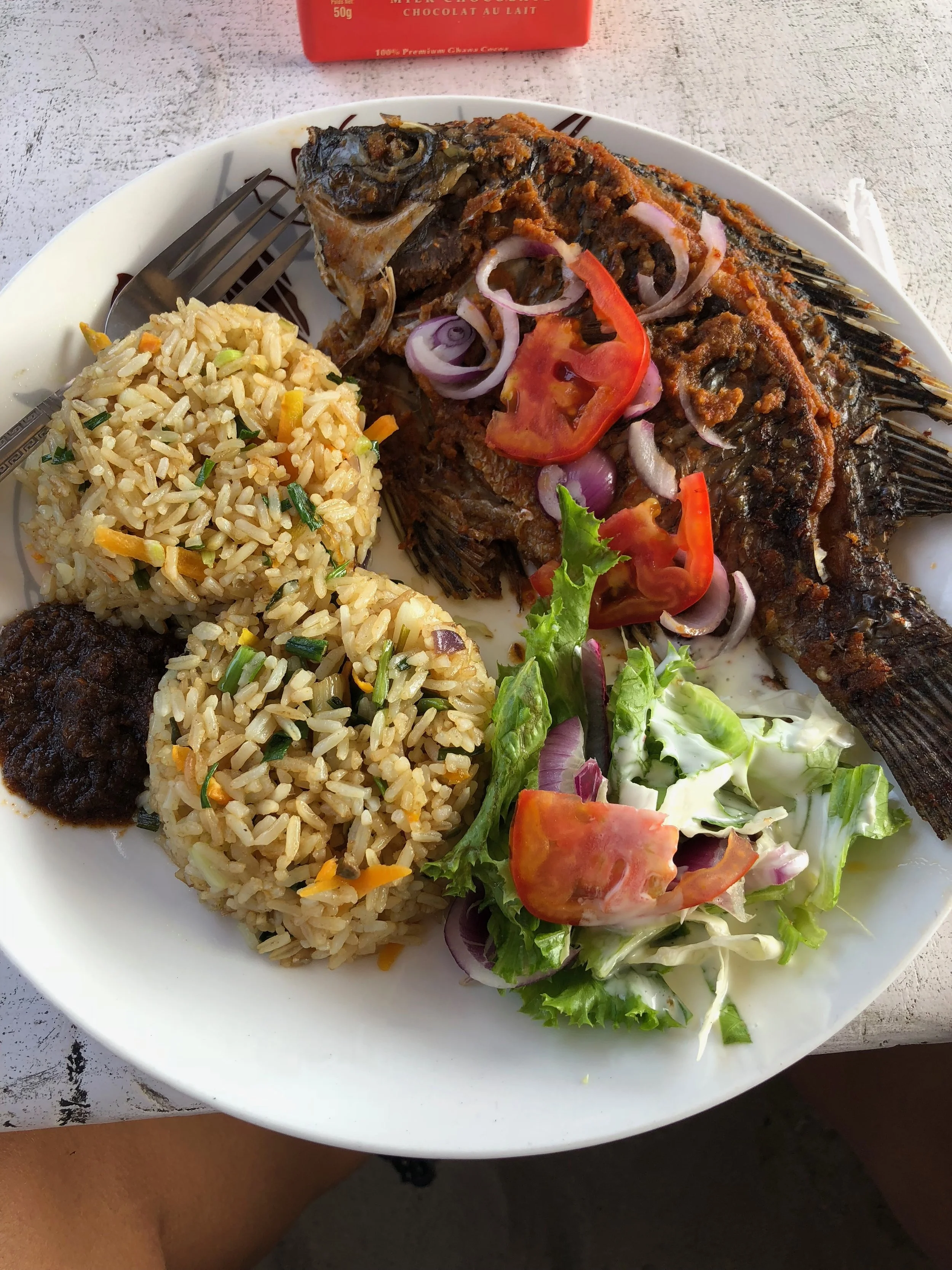 Typical Ghanaian meal with fish and jollof rice