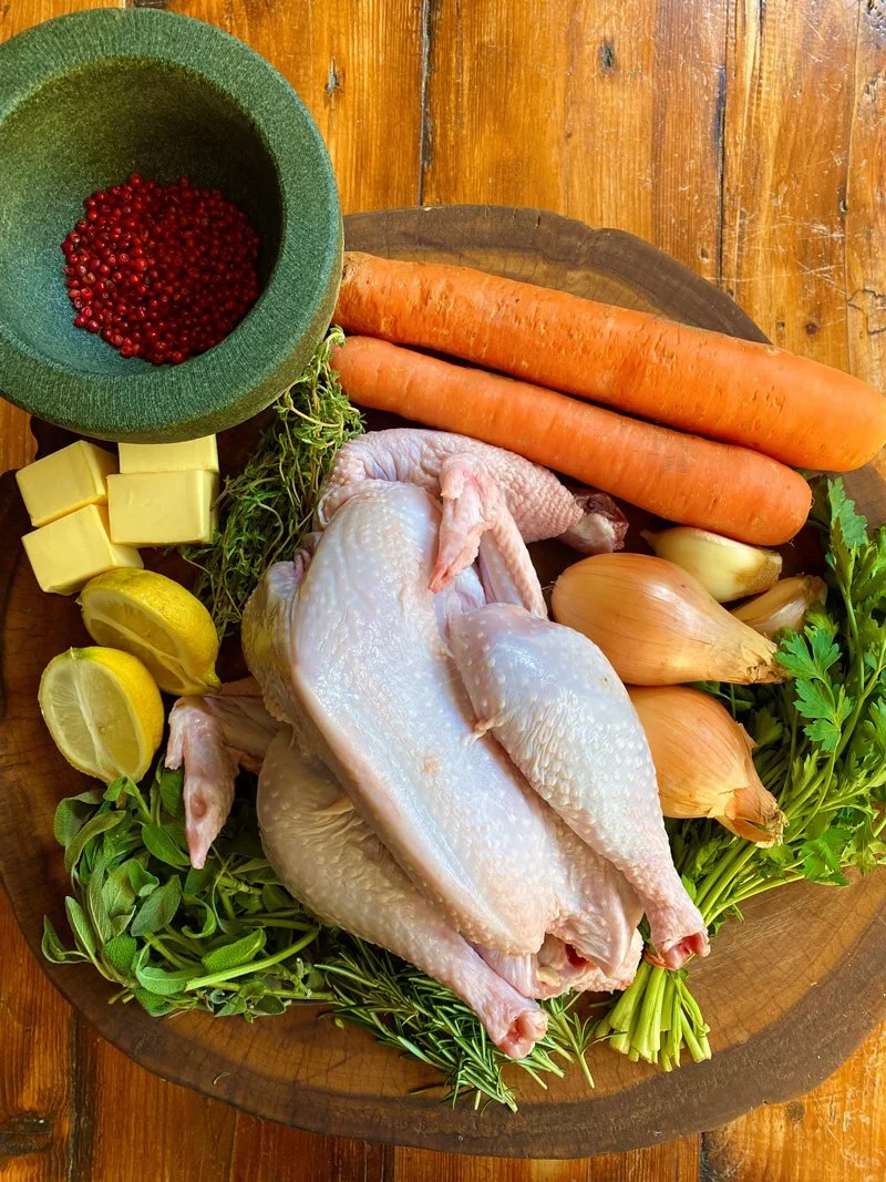 Potroasted Rooster with seasonal veggies, pink peppercorns, herb