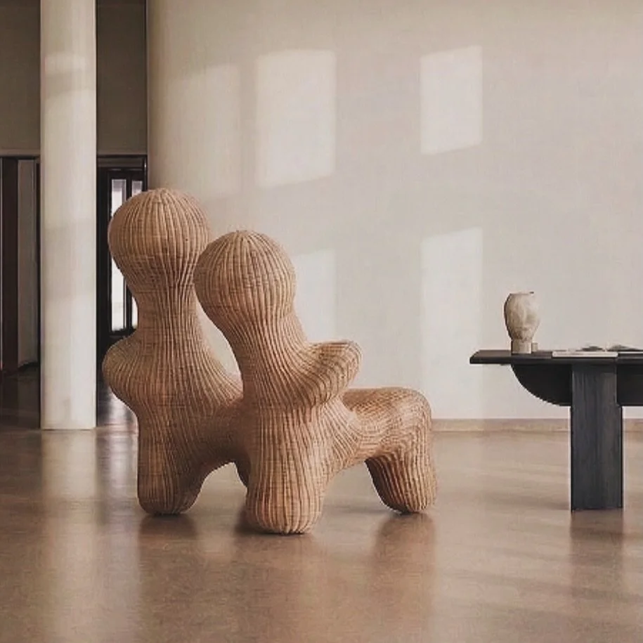 The embrace loveseat expands the narrative into a shared space; two presences held within a single, continuous form.

Tension softens into proximity; distance dissolves into connection.

Hand-sculpted in resin and finished with hand-woven rattan, the